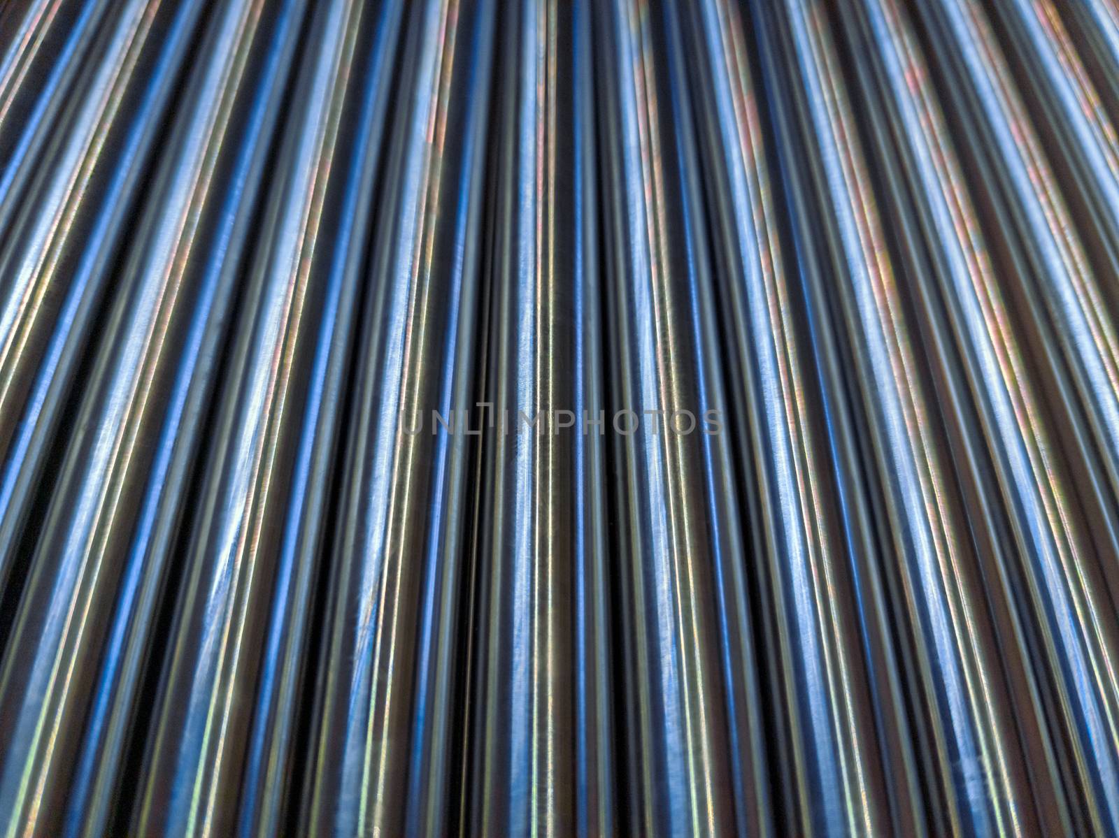 a simple abstract industrial close-up background of shiny cnc turned rods with linear perspective and selective focus