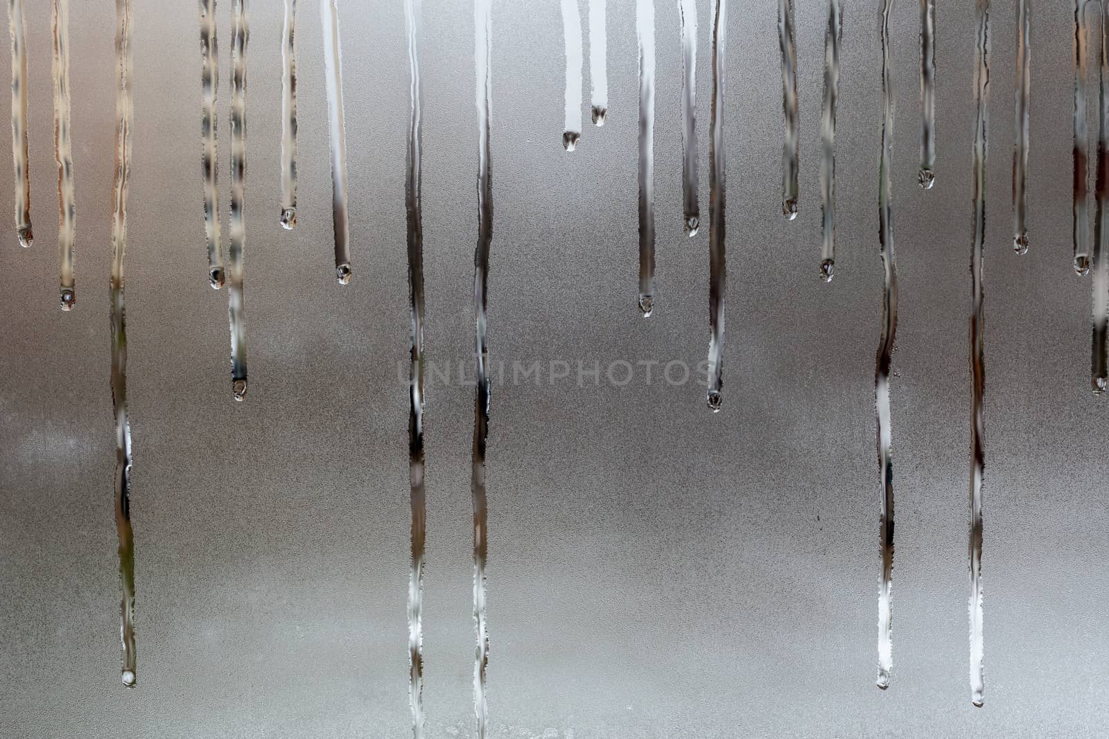 abstract background of wet window glass with water drop smudges - close-up with selective focus and background blur.