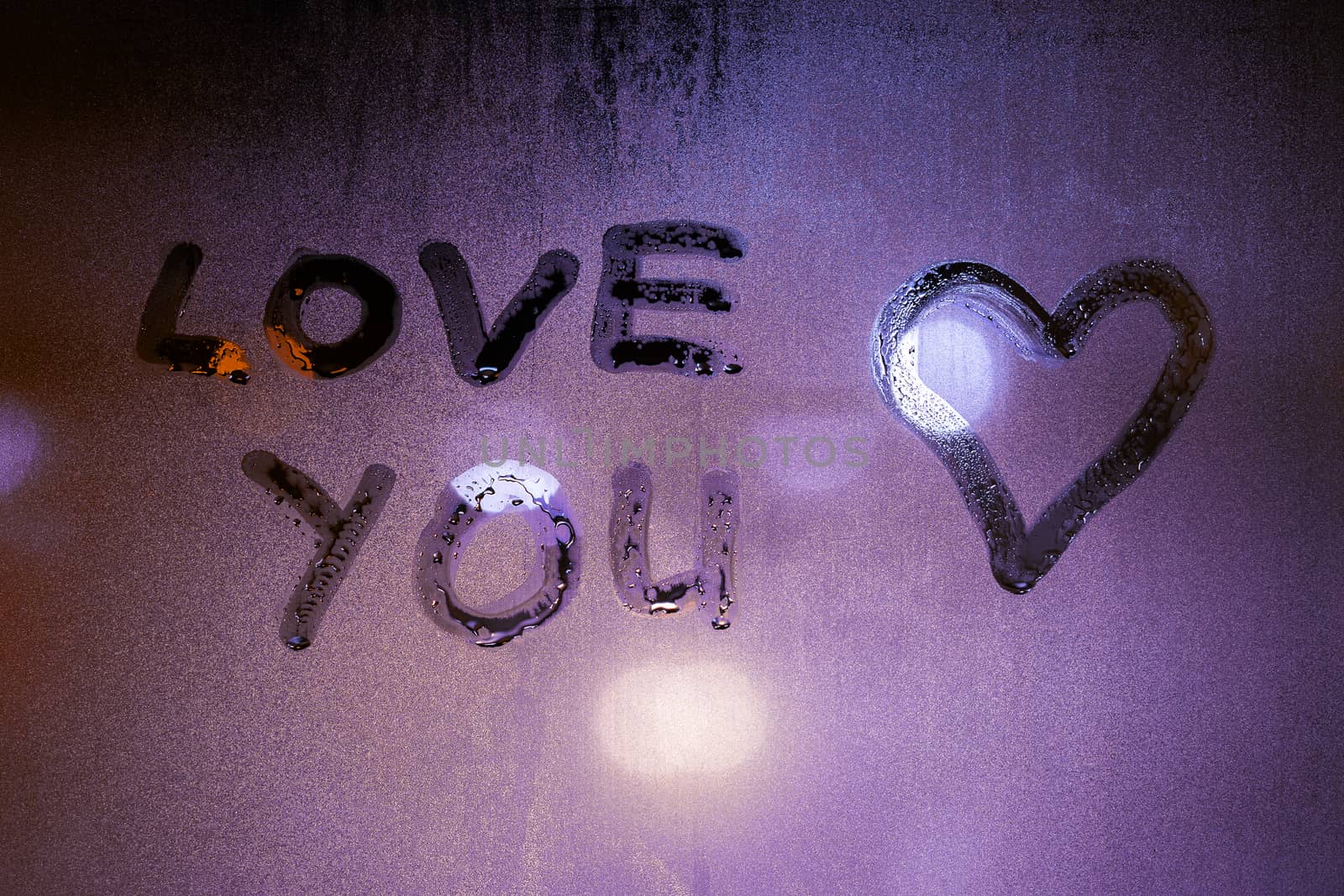 the words love you handwritten on foggy night window glass and heart symbol by z1b