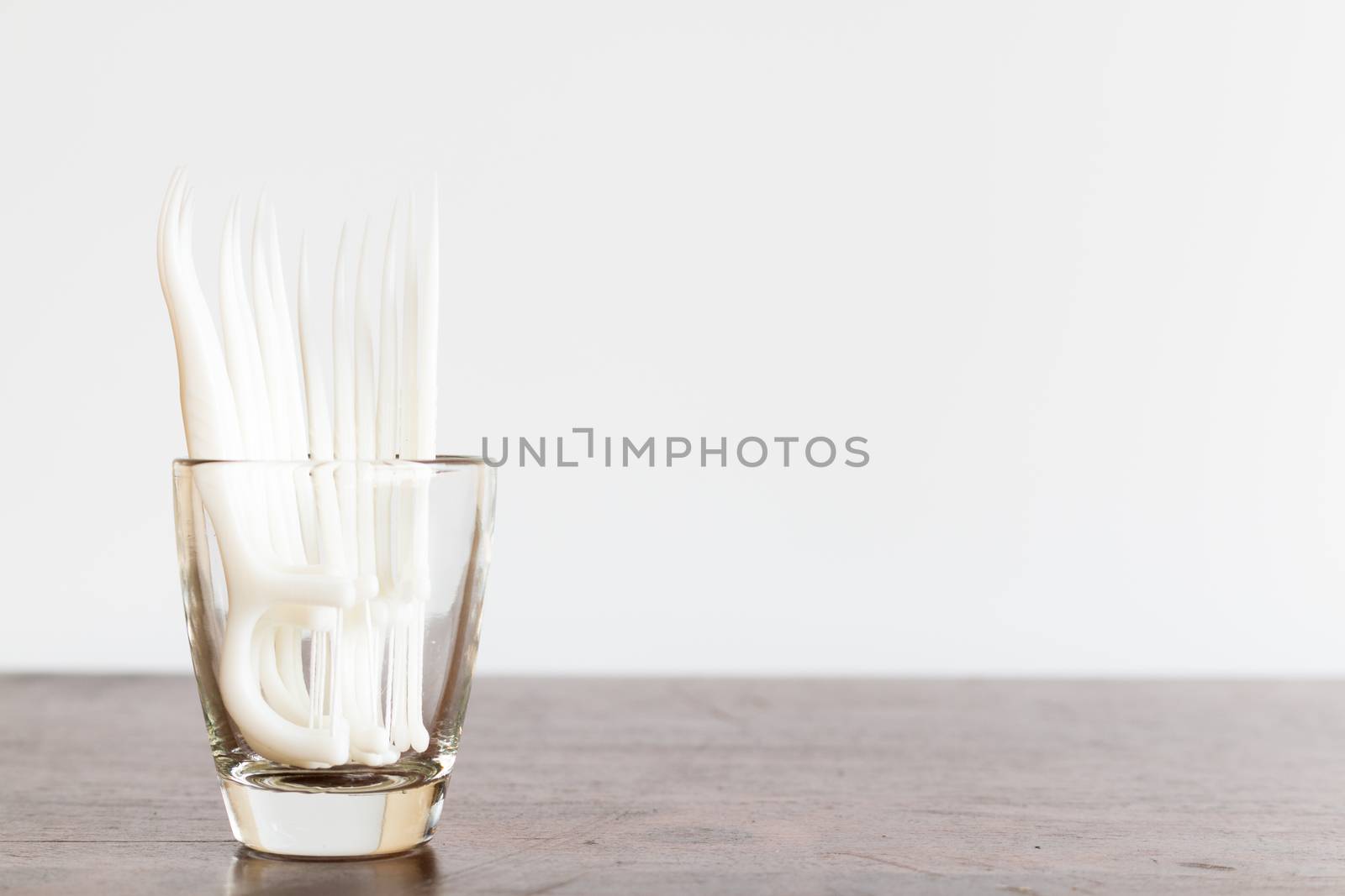 Oral Device : Dental floss in glass on wooden background