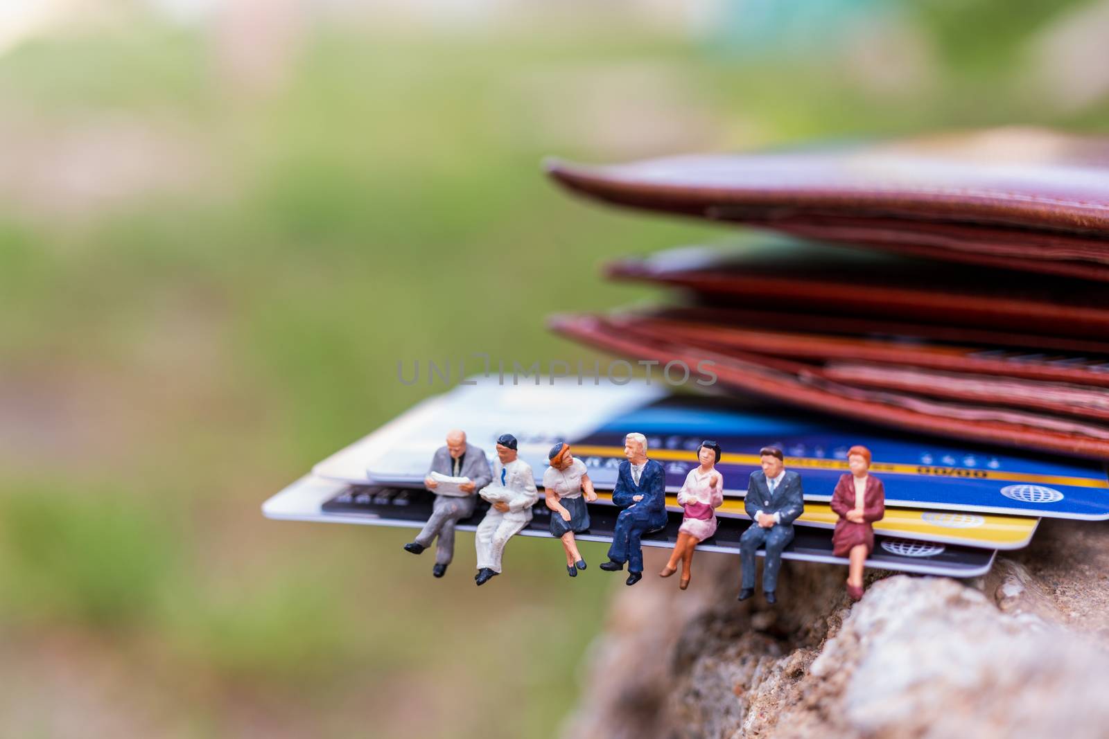 Miniature people : business people sitting on Credit card by sirichaiyaymicro