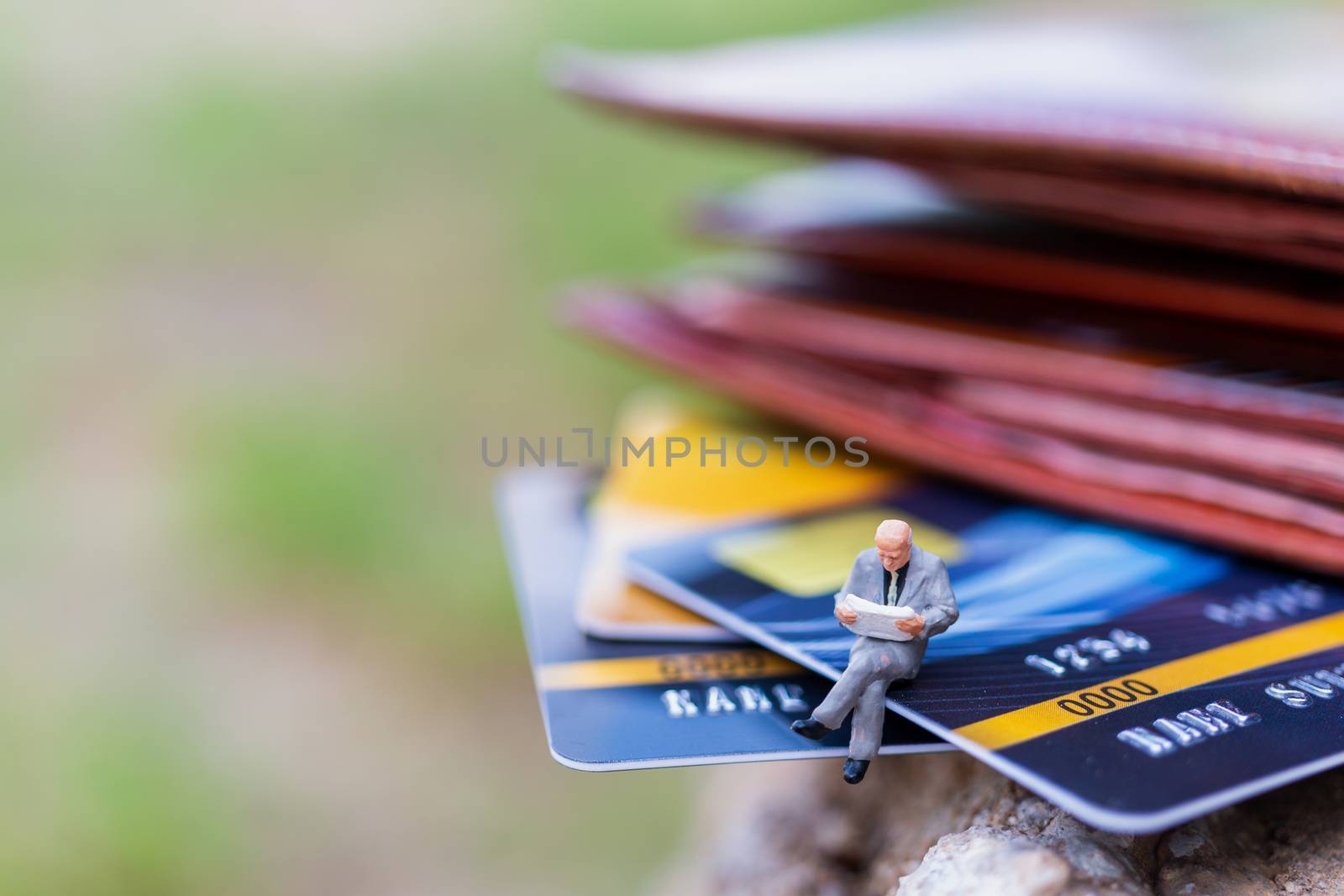 Miniature people : business people sitting on Credit card by sirichaiyaymicro