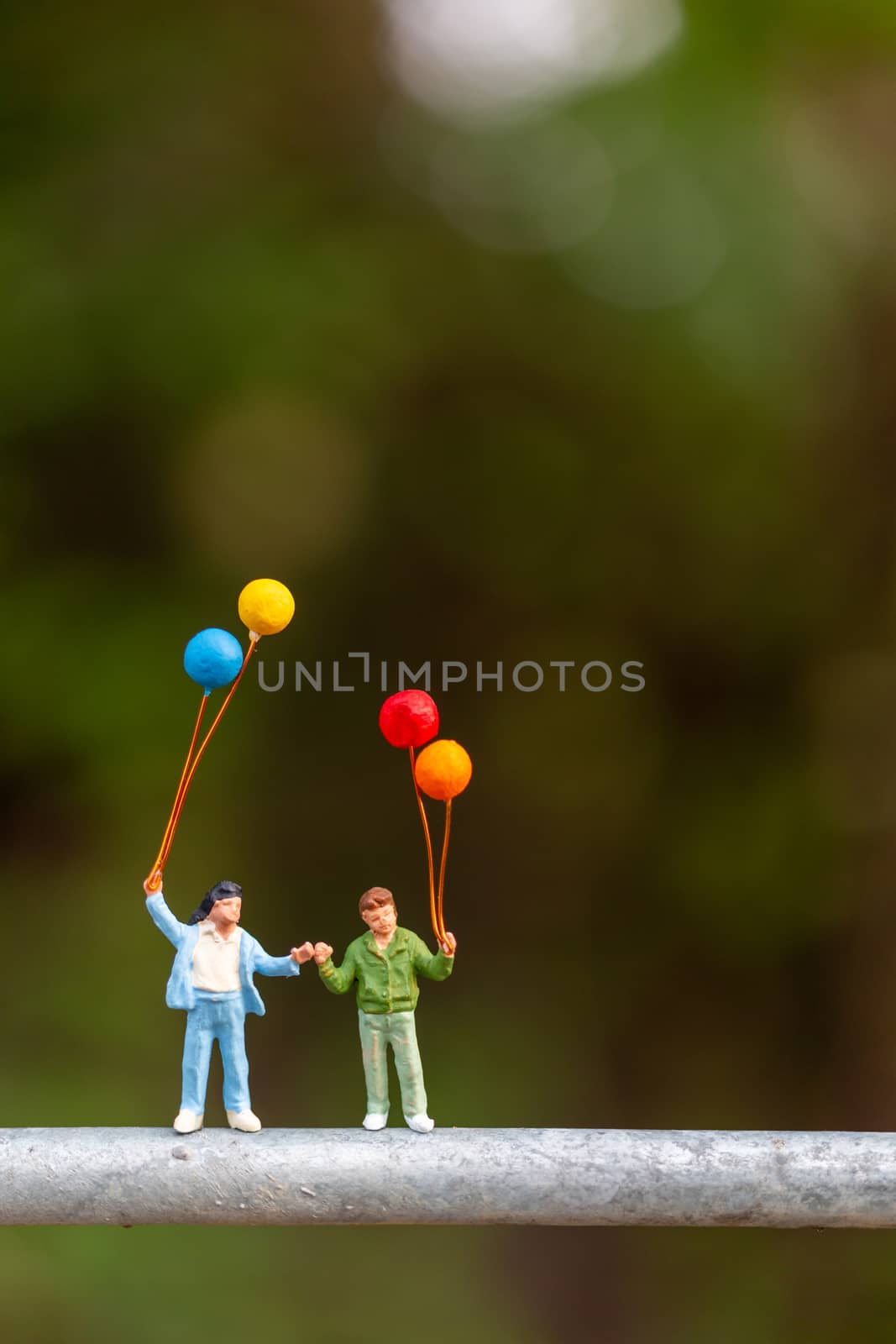 Miniature people : Happy family  holding colorful balloons  by sirichaiyaymicro