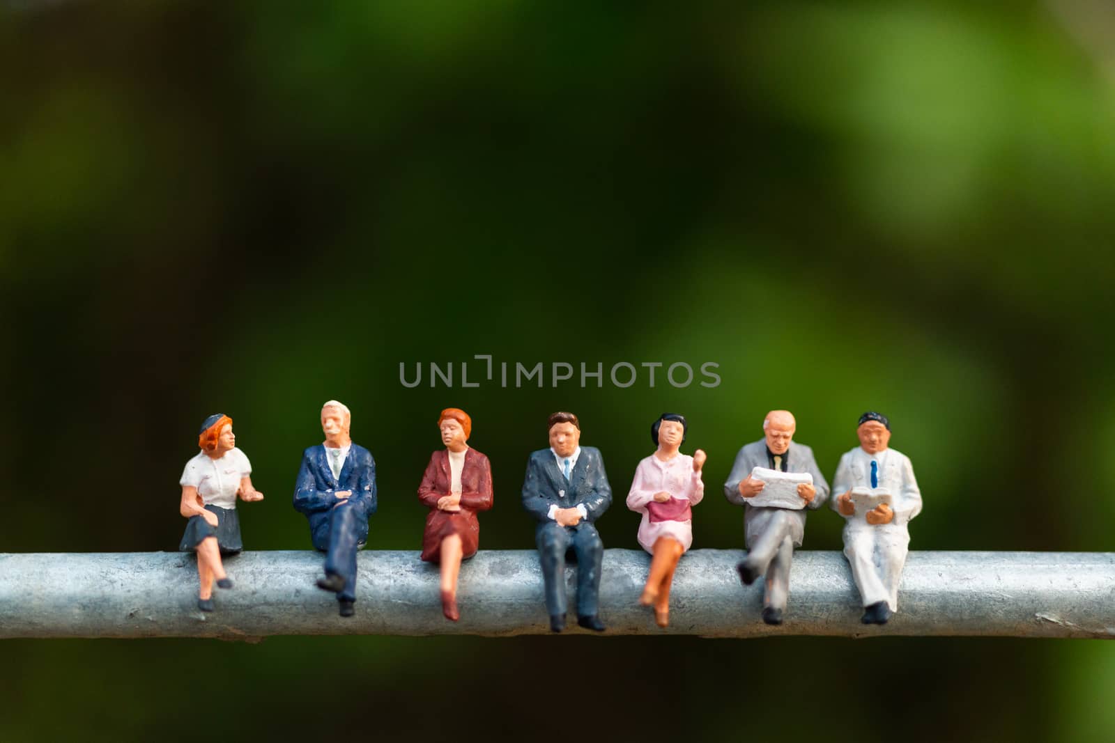 Miniature people : business people sitting on a  wire with green by sirichaiyaymicro