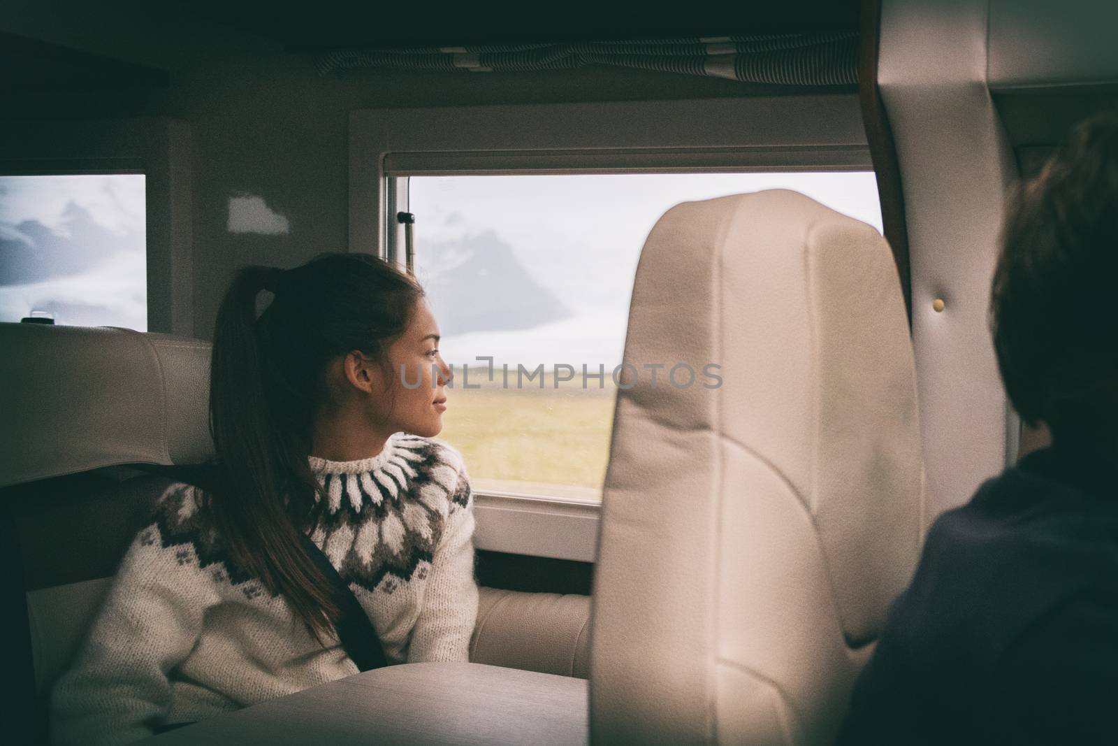 RV camper van travel Asian girl sitting in back of motorhome car on Iceland road trip. Europe vacation lifestyle. by Maridav