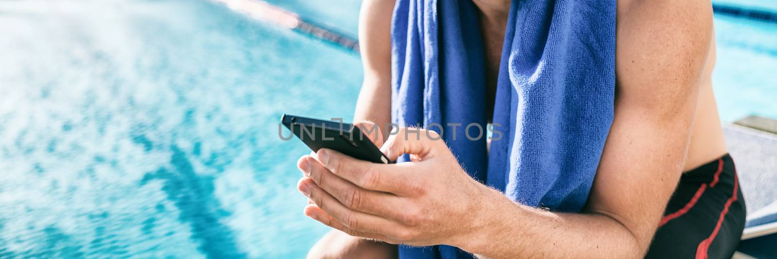 Swimmer athlete using mobile phone during triathlon race. Man at swimming pool texting sms message on cellphone training swim workout.