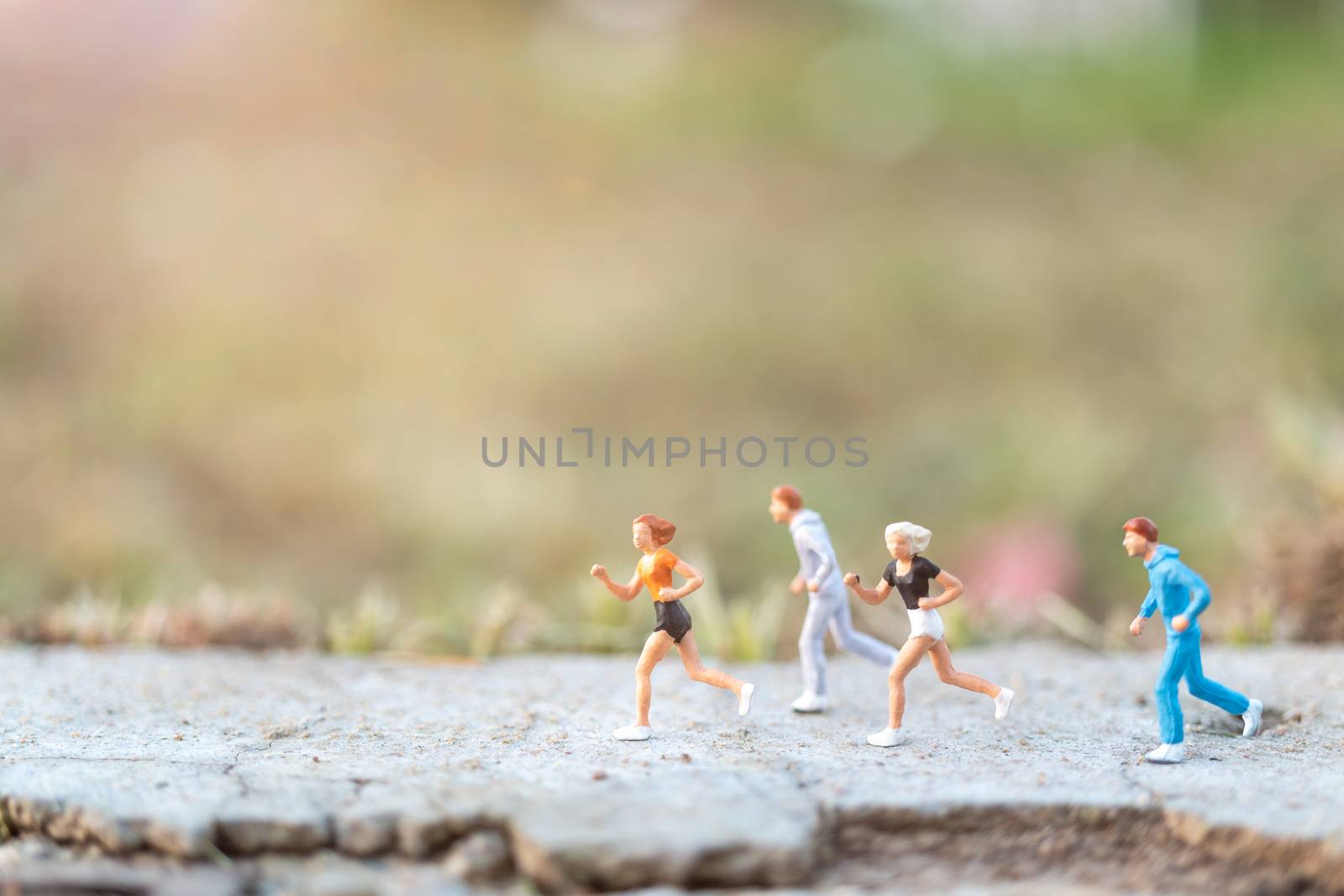 Miniature people : Running on the road with nature background  by sirichaiyaymicro