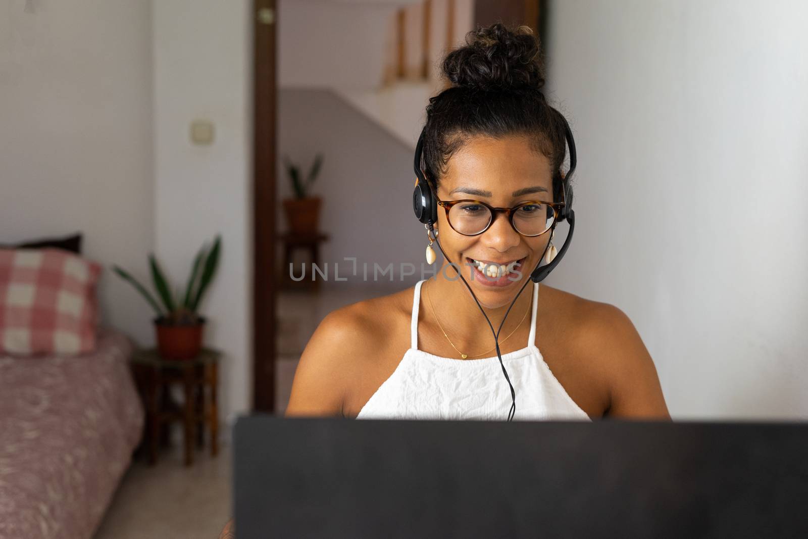 Working brazilian young woman in bedroom. Telemeeting. Video conference. Remote work. Call center home.