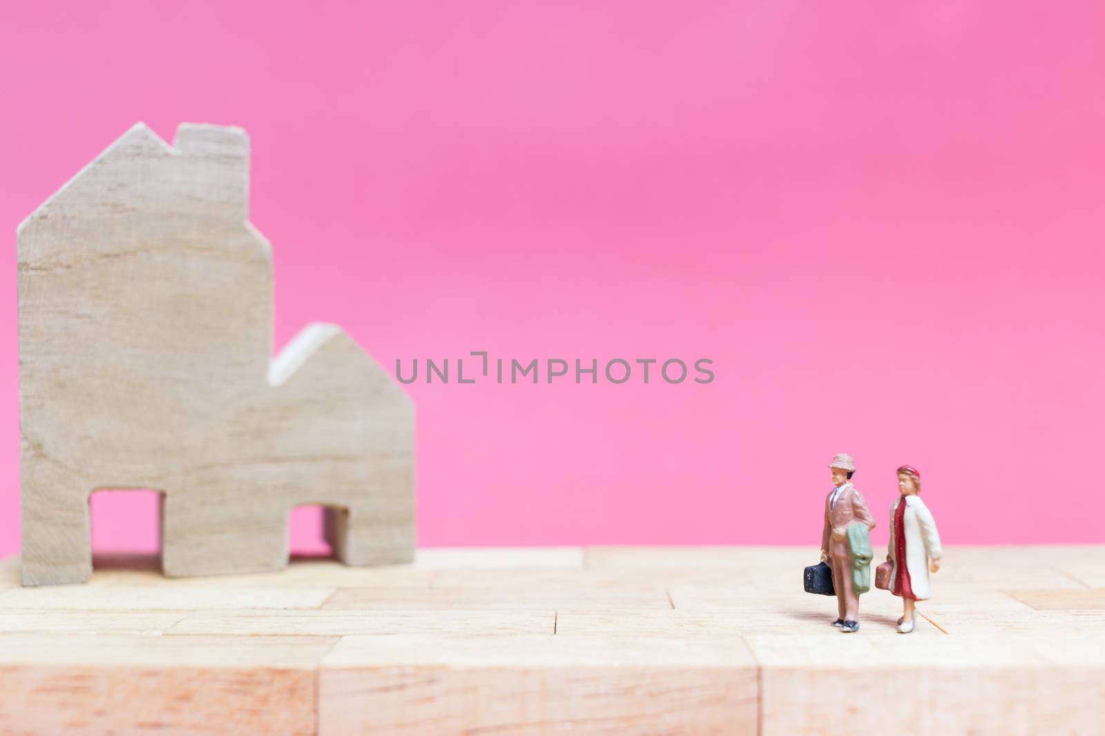 Miniature people : Couple with house on pink background , Valentine's day concept