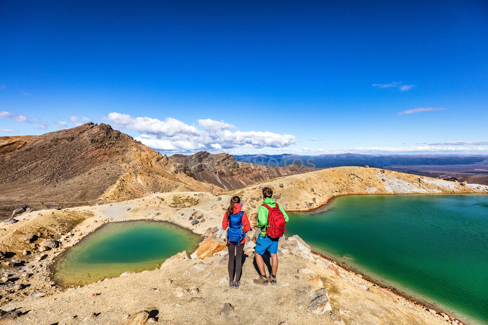 New Zealand popular tourist hiking hike in Tongariro Alpine Crossing National Park. Tramping trampers couple hikers walking on famous destination in NZ by Maridav