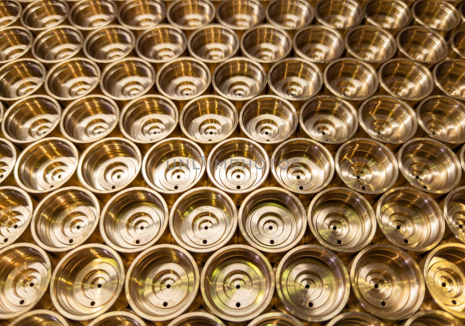 an abstract perspective industrial close-up background of shiny brass metal threaded hexagonal fitting parts.