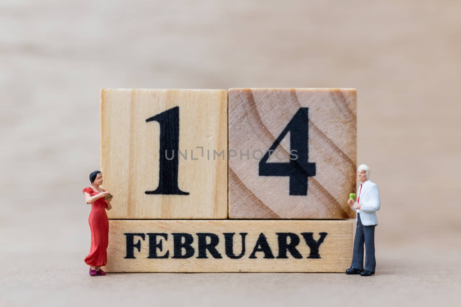 Miniature people couple with wooden block 14 FEB on wooden background, happy valentines day concept