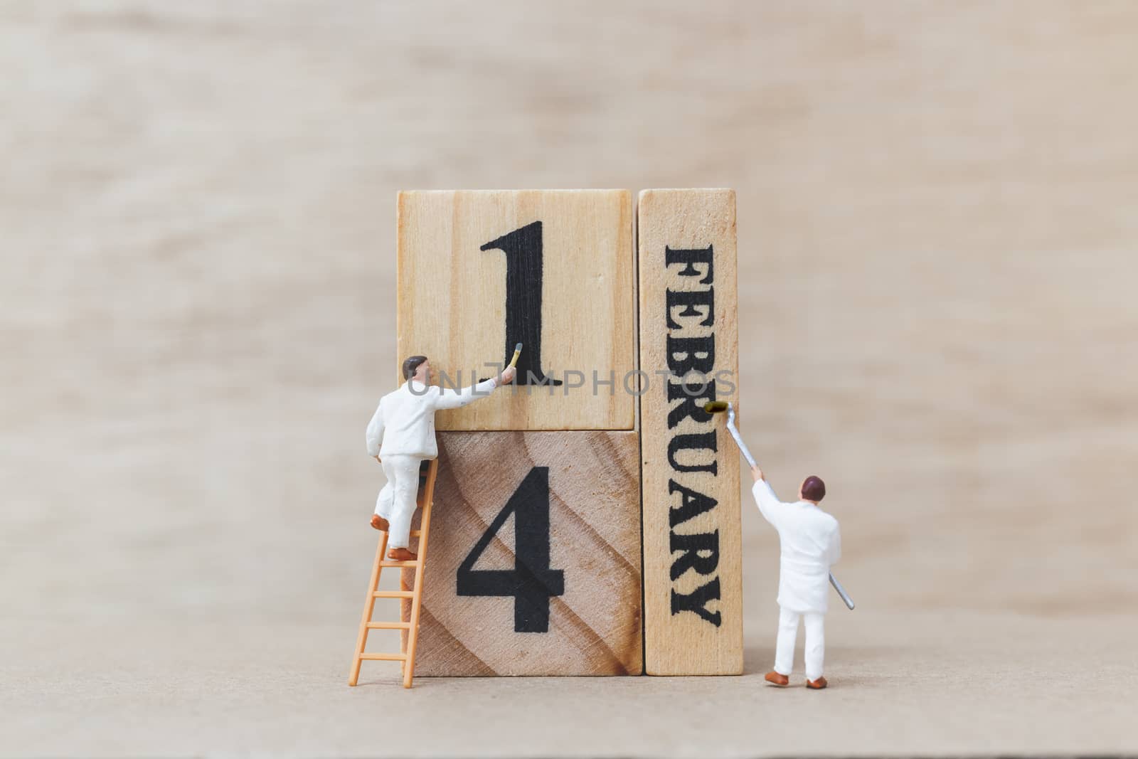 Miniature people painting wooden block 14 FEB on wooden background, happy valentines day concept