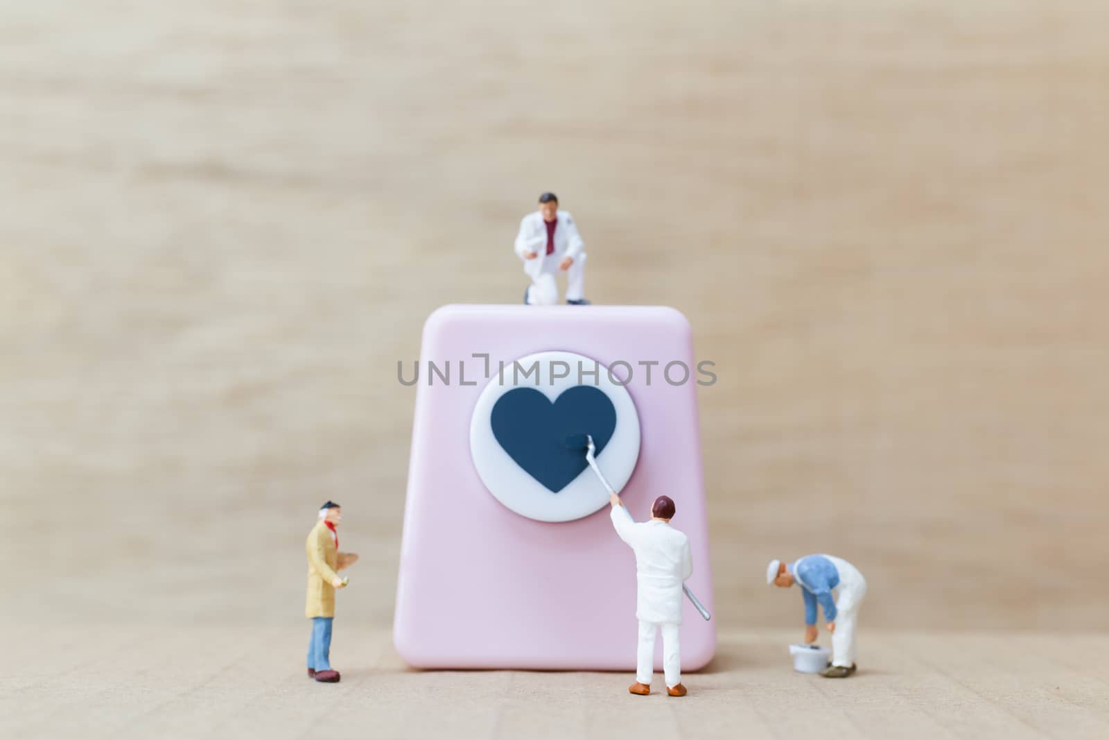 Miniature people painting Heart shaped punching machine with copy spaces for your text , Valentine day concept.