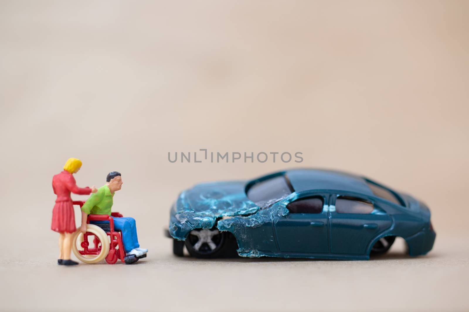 Miniature people : Disabled man sitting in wheelchair  on on wooden background , Accident concept