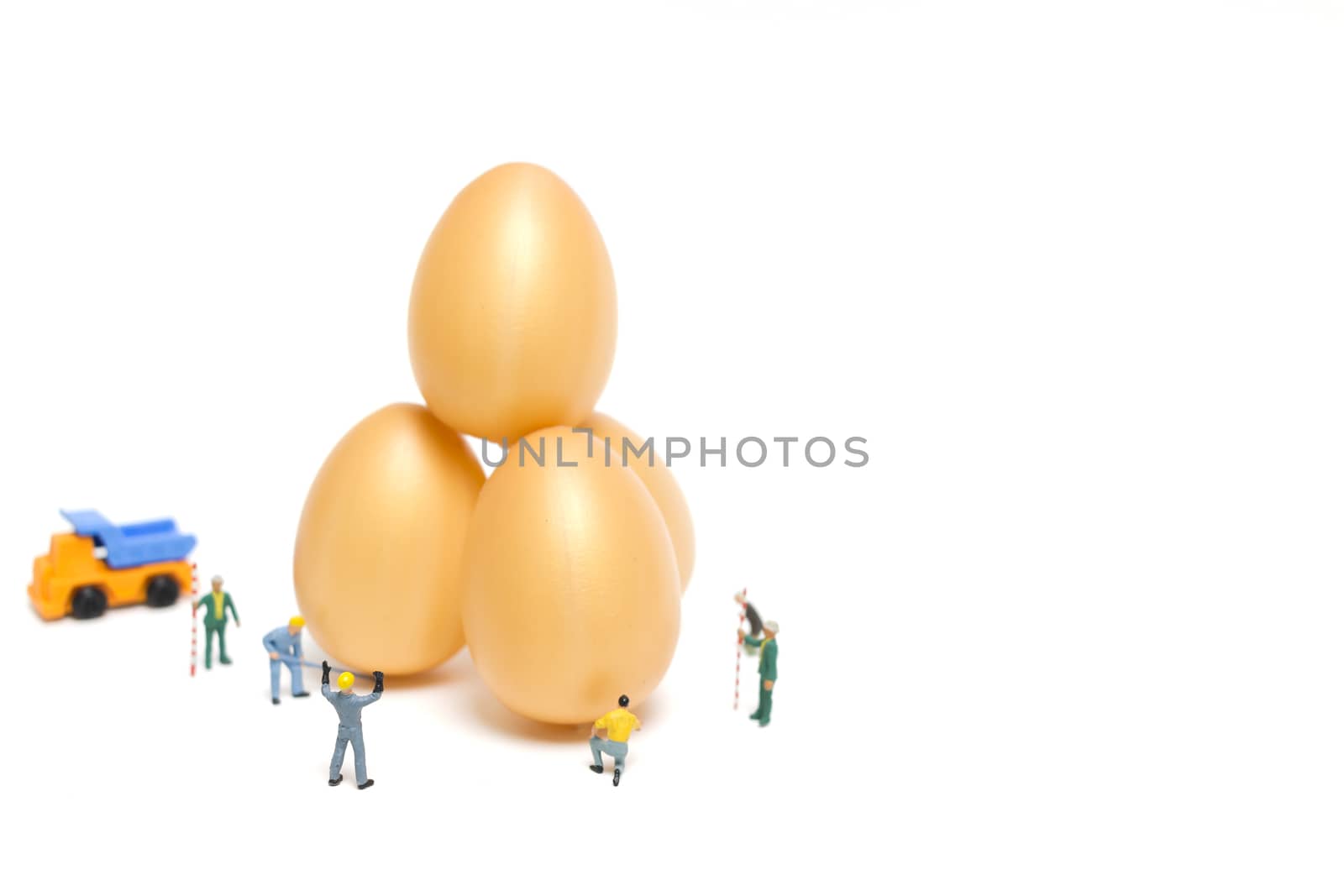 Miniature people work at Easter-eggs for Easter day on white background