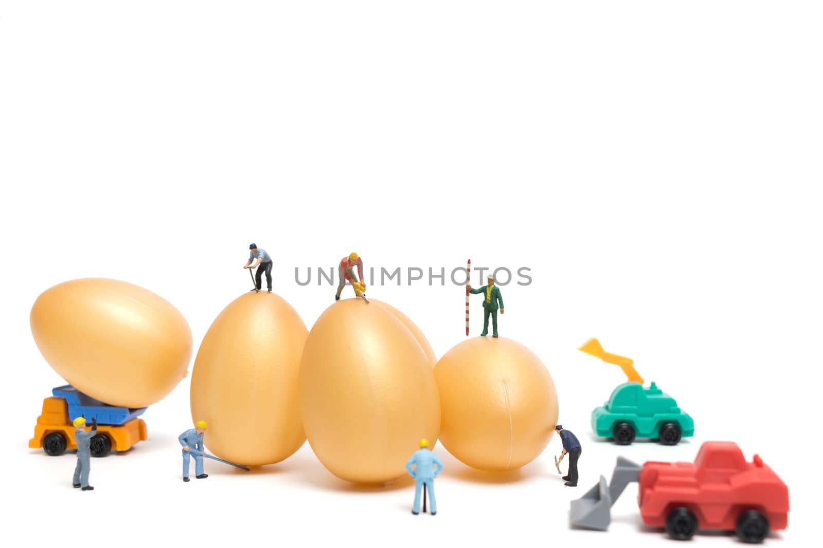 Miniature people work at Easter-eggs for Easter day on white background