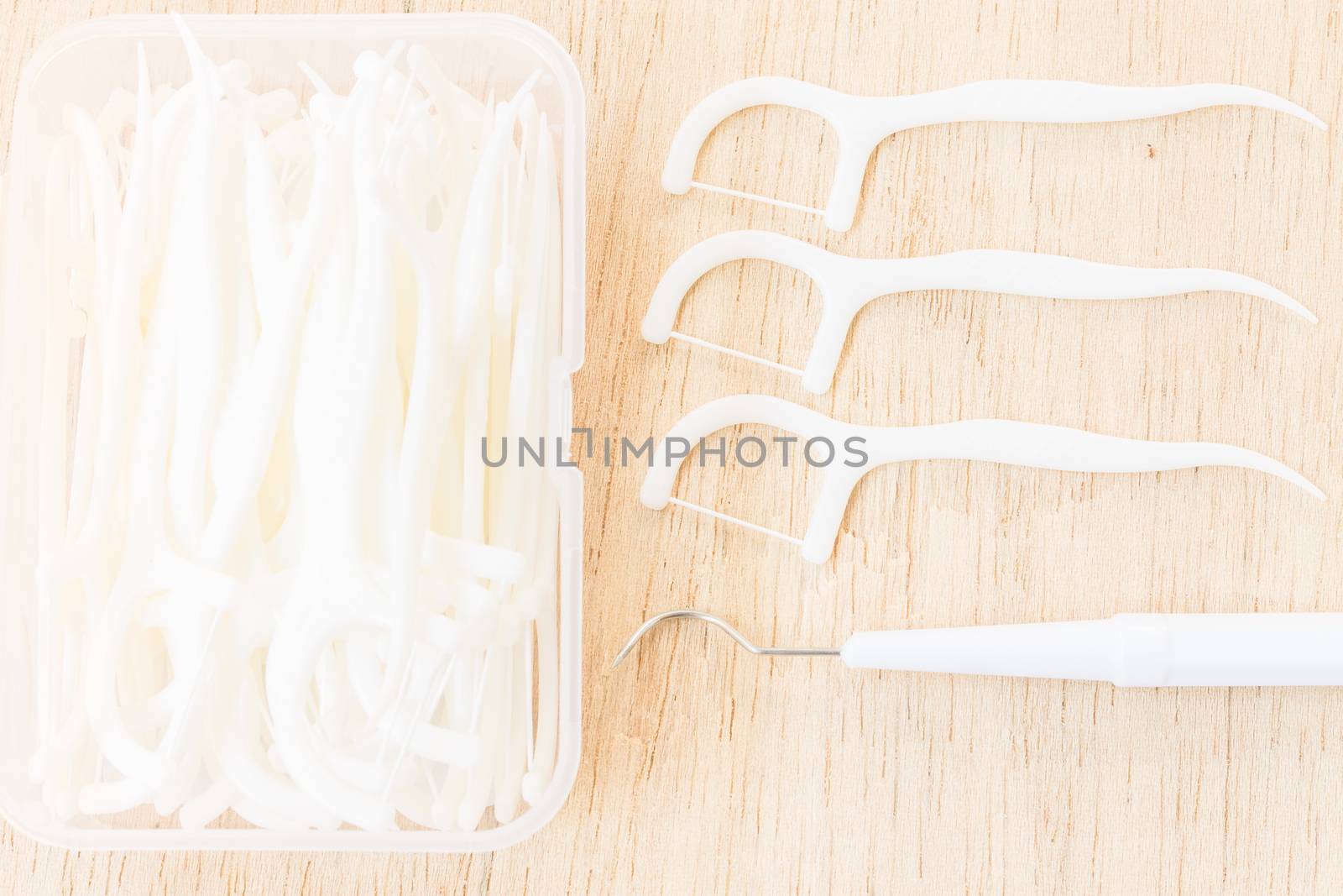 Oral Device : A box of white dental floss on wooden background by sirichaiyaymicro