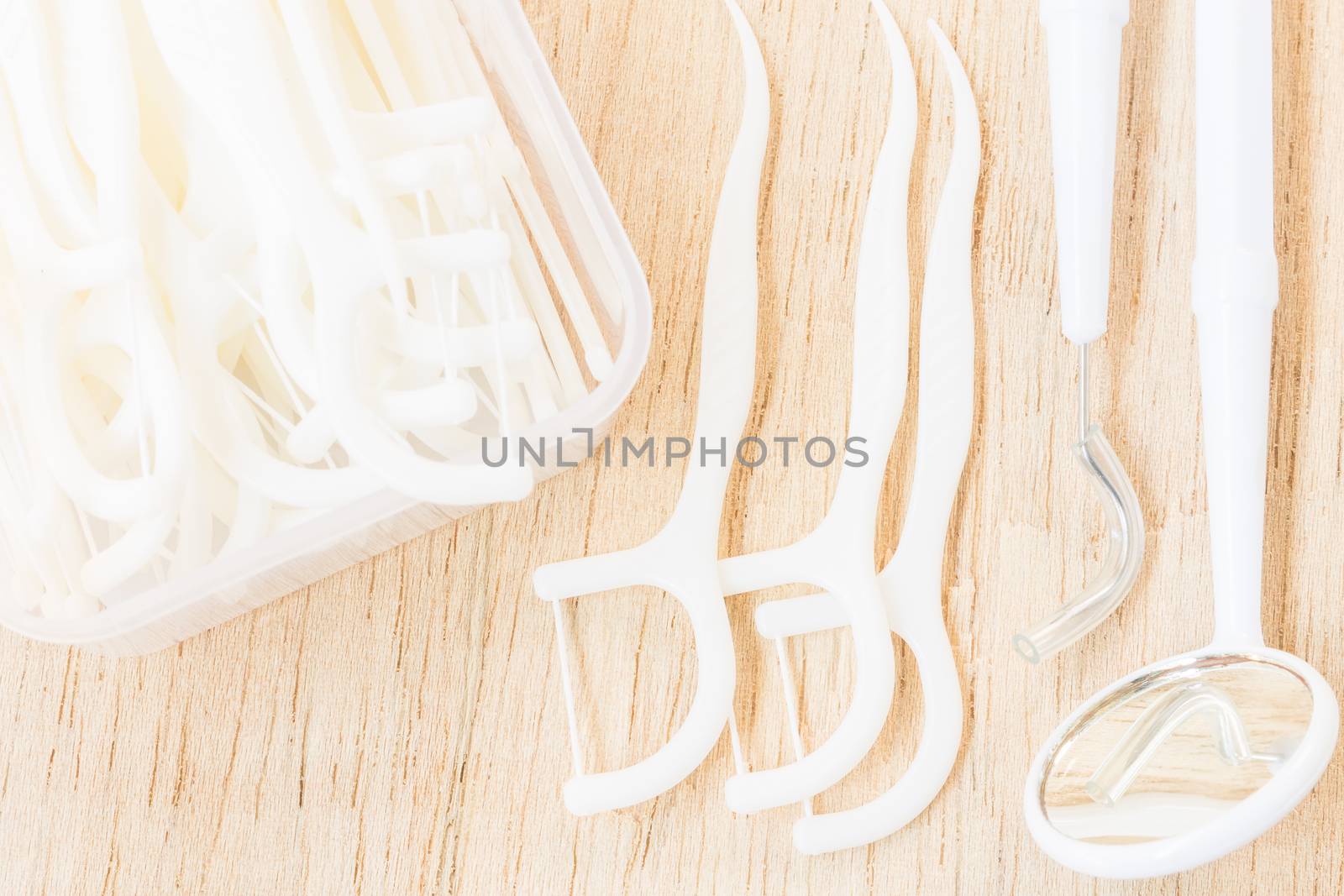 Oral Device : A box of white dental floss on wooden background by sirichaiyaymicro