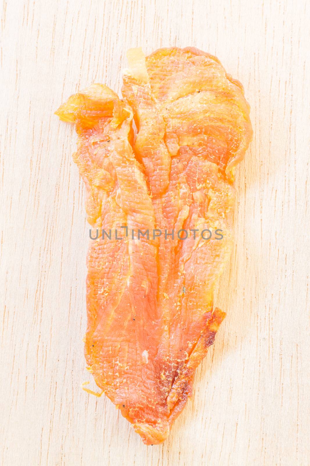 Dried chicken jerky for dogs on wooden background
