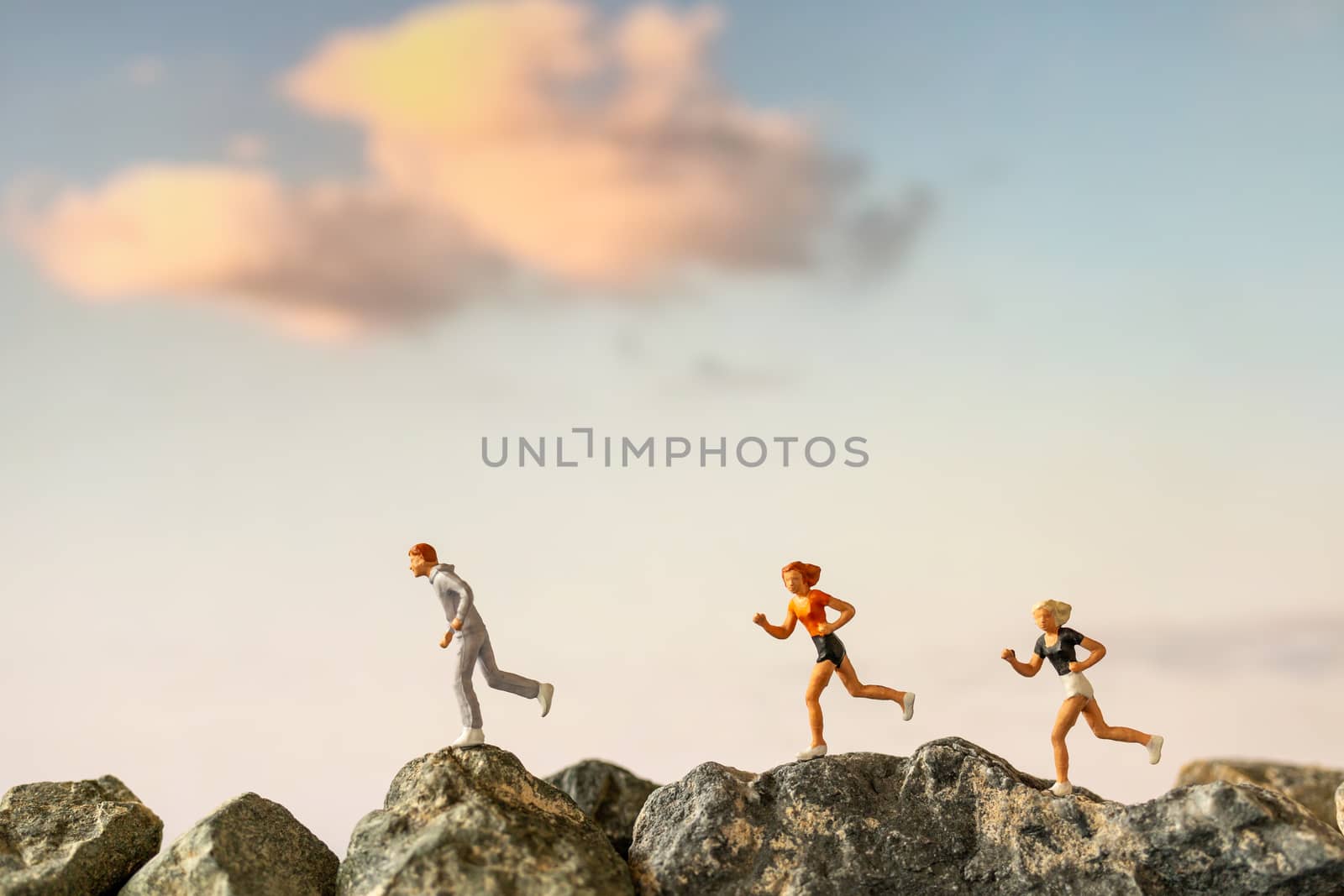 Miniature people : Running on rock cliff with nature background  by sirichaiyaymicro