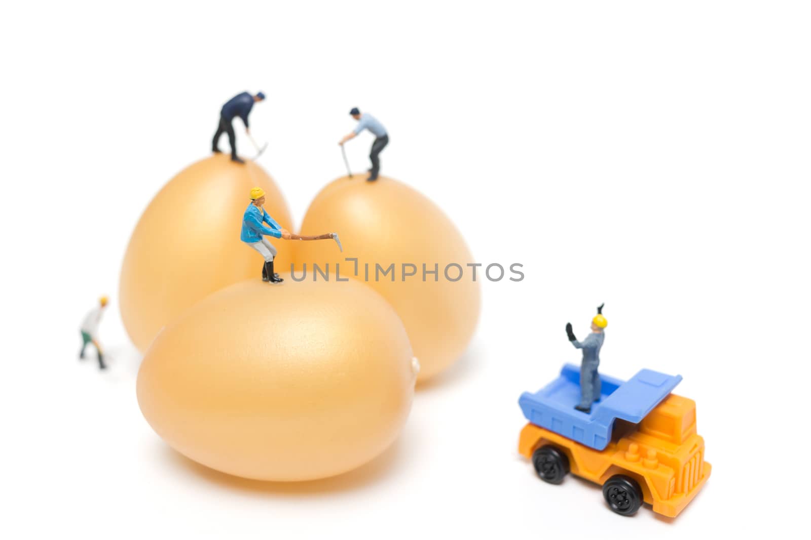 Miniature people work at Easter-eggs for Easter day on white background