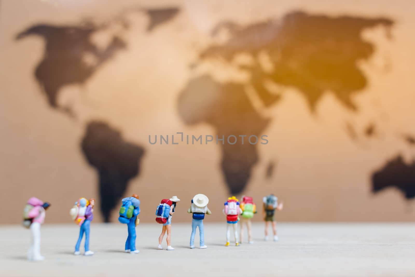 Miniature people travelers walking on world map , Traveling and exploring the world Concept