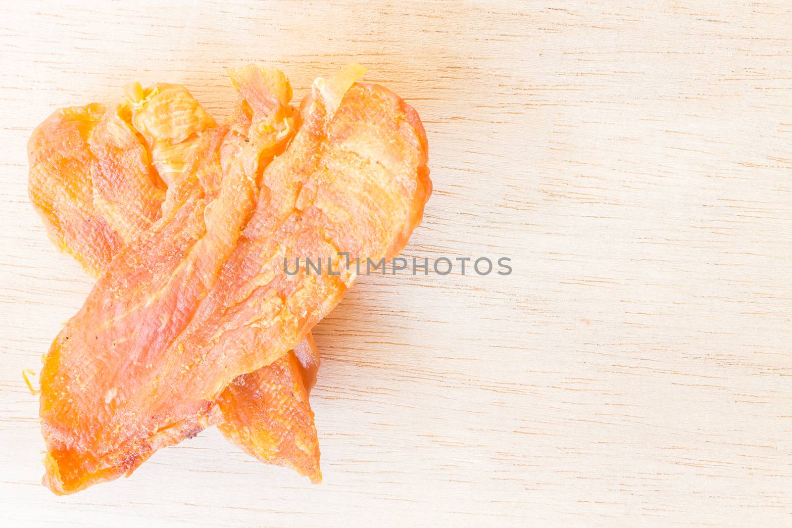 Dried chicken jerky for dogs on wooden background