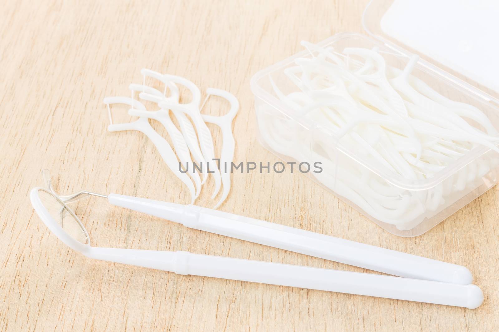 Oral Device : A box of white dental floss on wooden background by sirichaiyaymicro