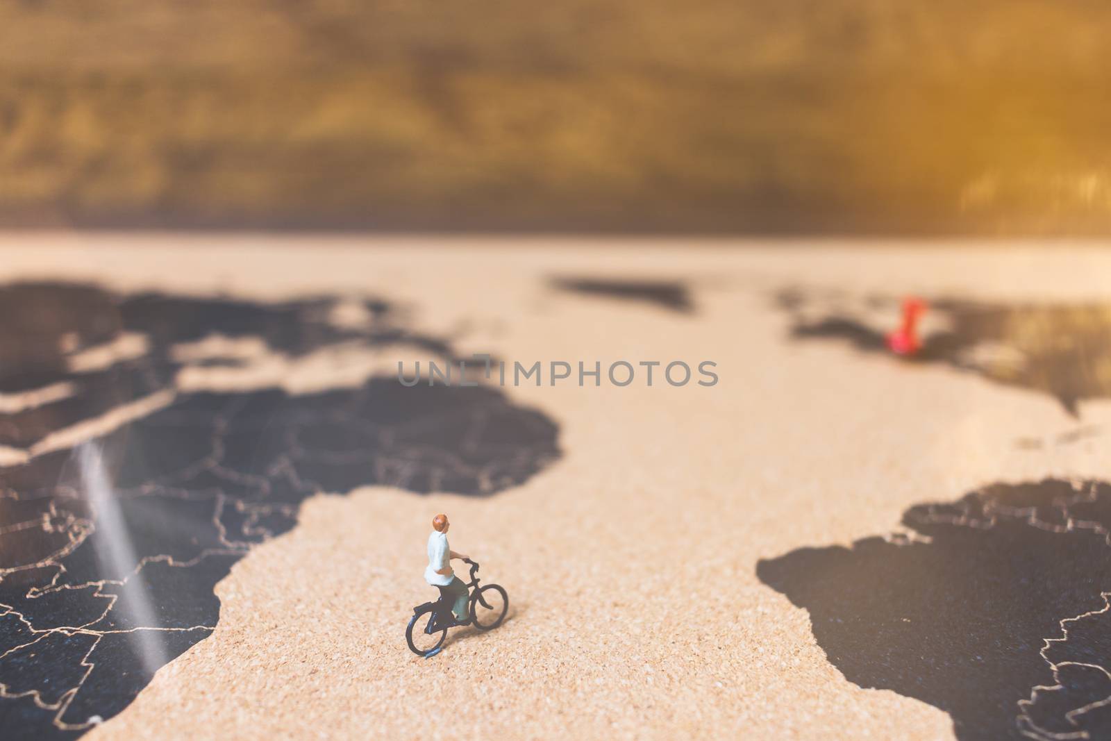 Miniature people travelers riding bicycle on world map , Traveling and exploring the world Concept