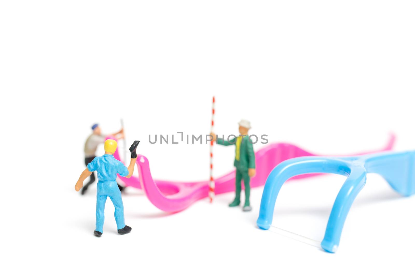 Miniature people : The team work on Dental floss isolate on white background , Dental clinic concept