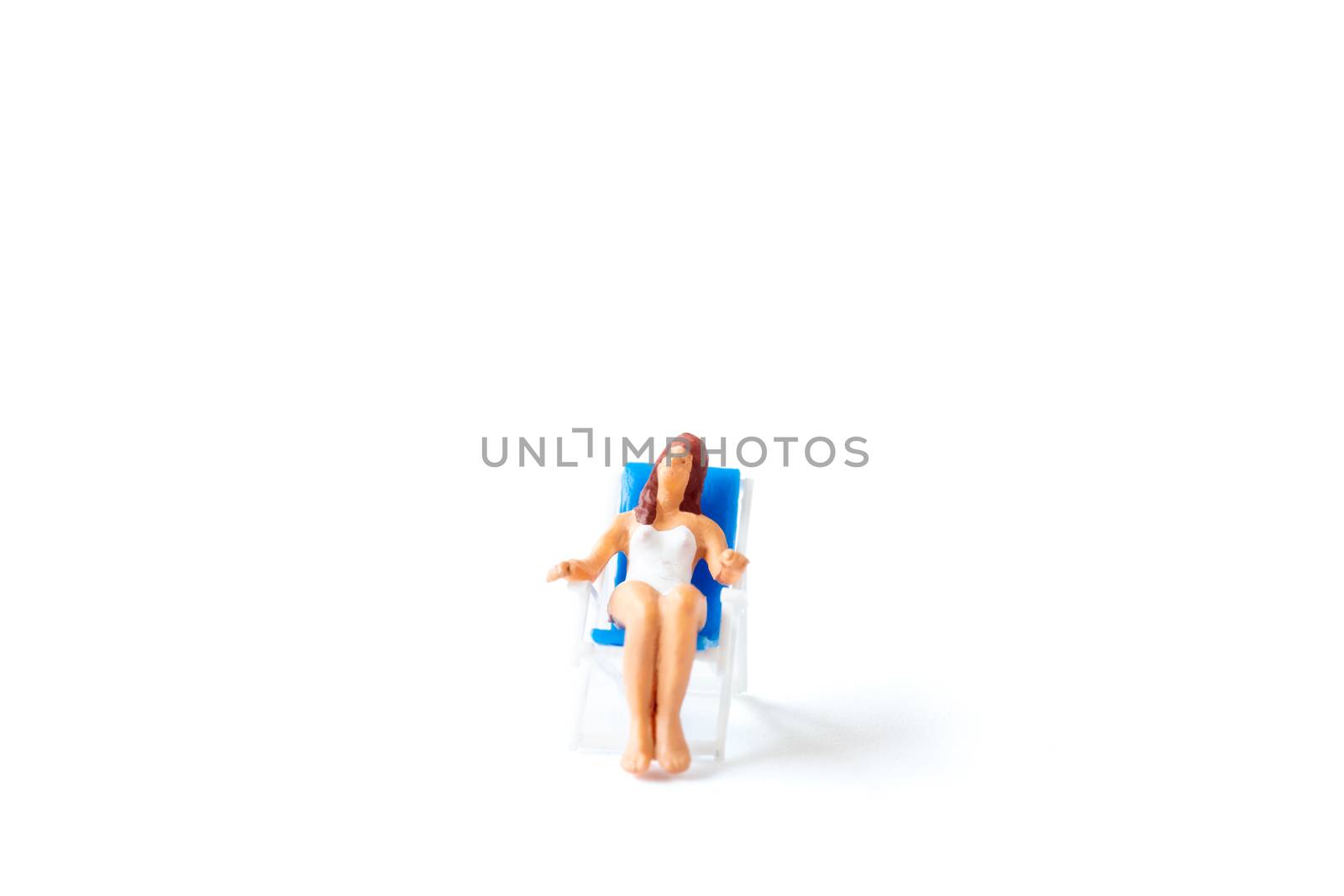 Miniature people sunbathing on deck chairs on white background , Summer time concept