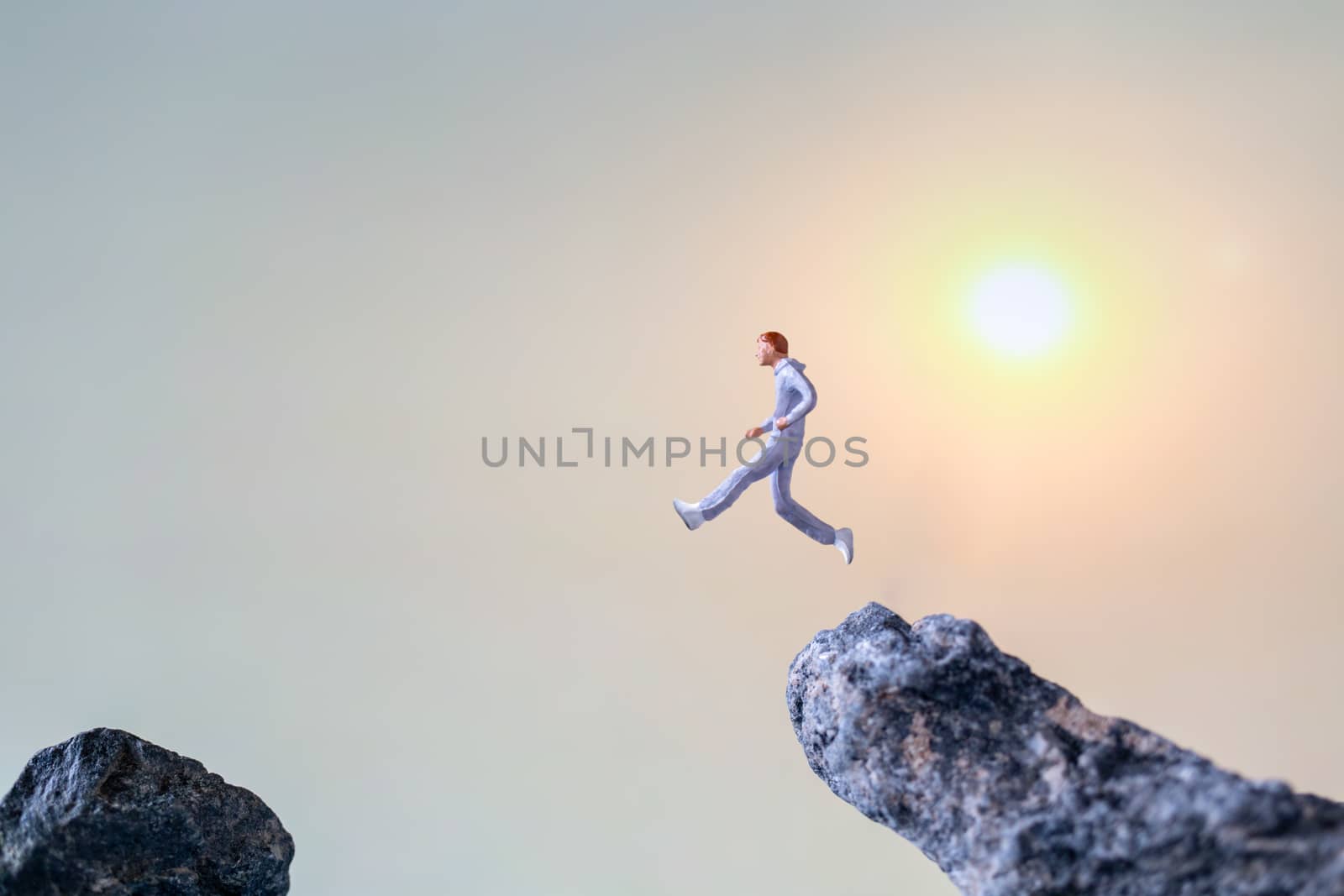 Miniature people : Running on rock cliff with nature background , Health And lifestyle concepts