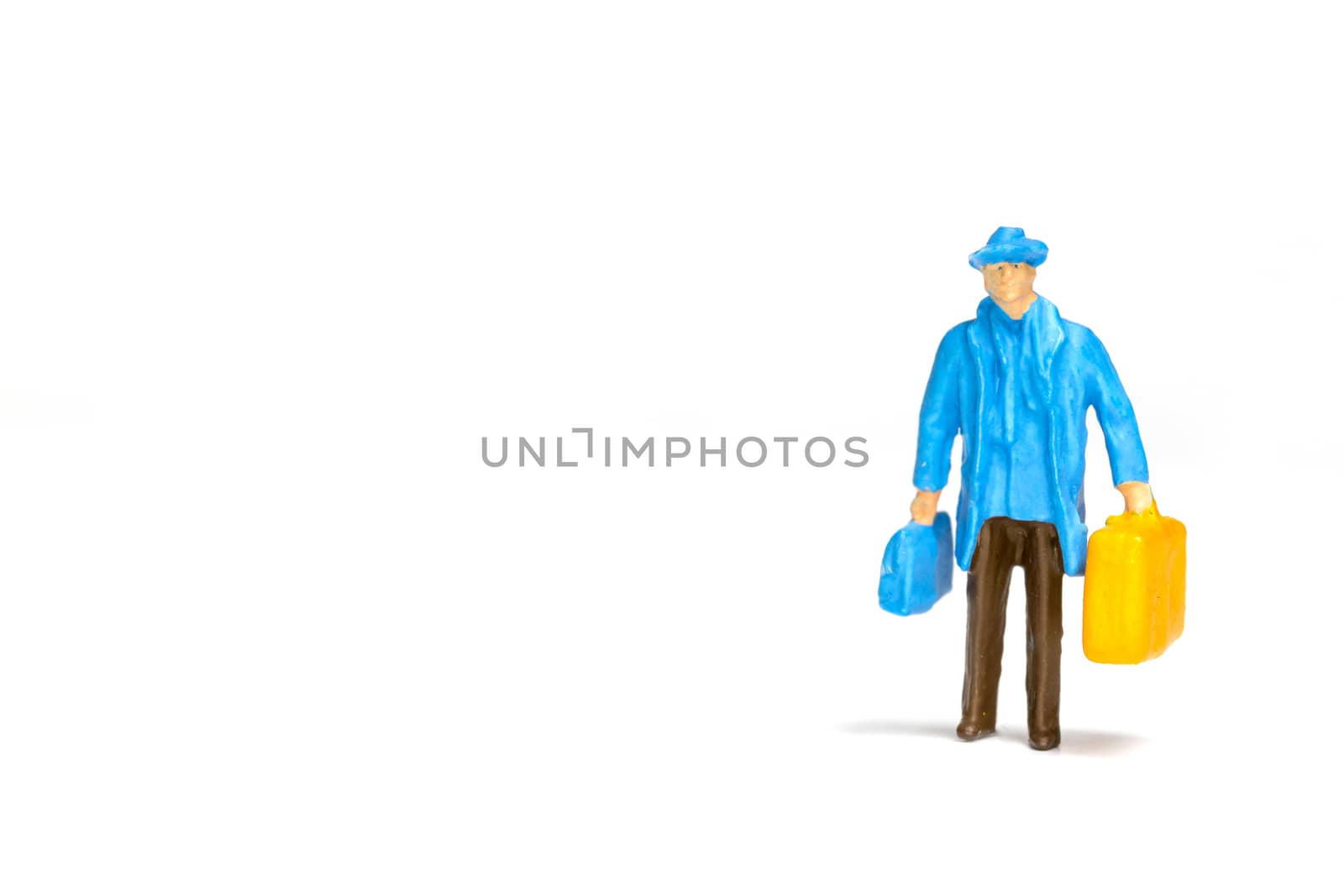 Miniature people ; Traveler holding a handbag standing on white background , Travel concept