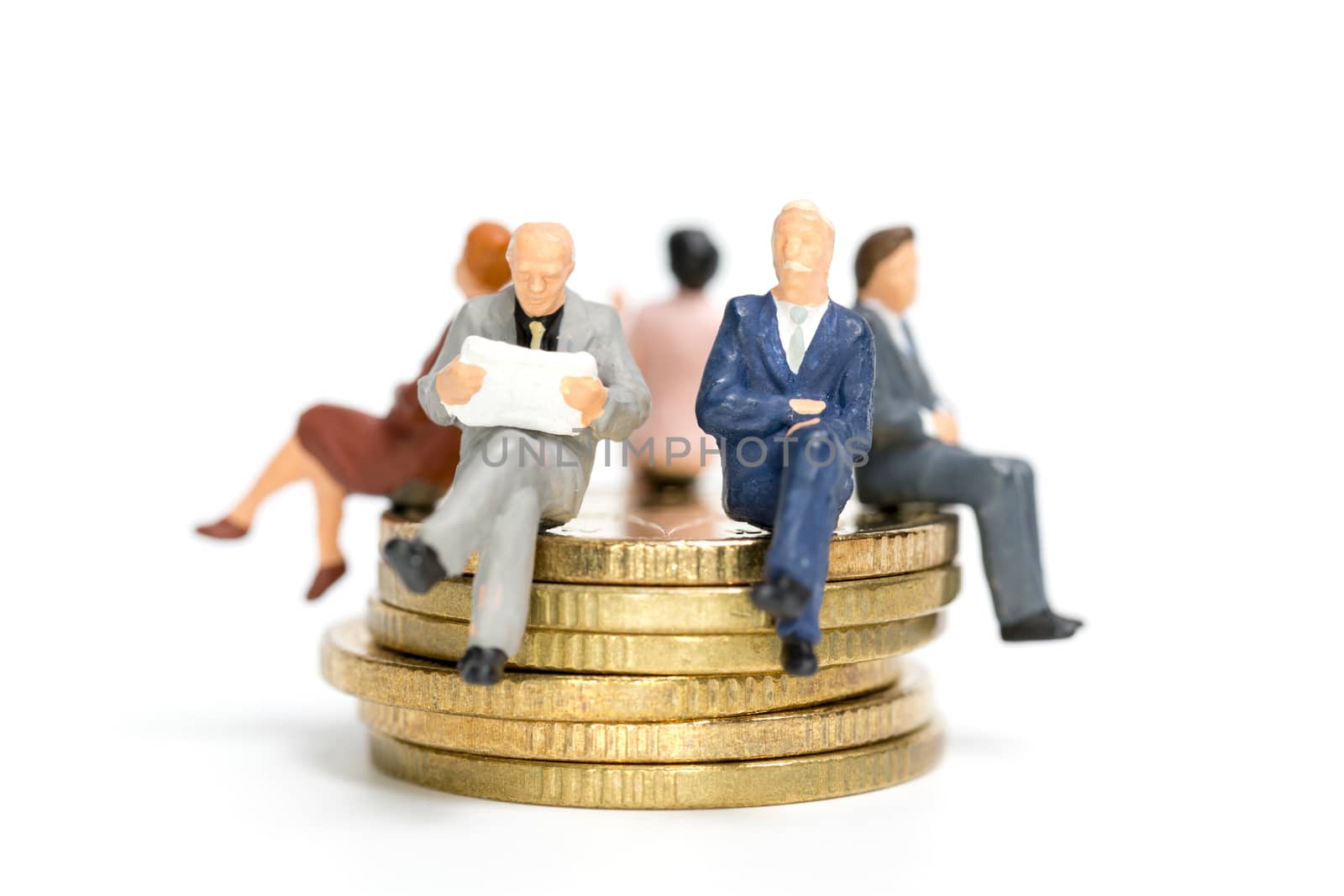 Miniature people: Businessman sitting on stack of coin , Money and financial concepts.