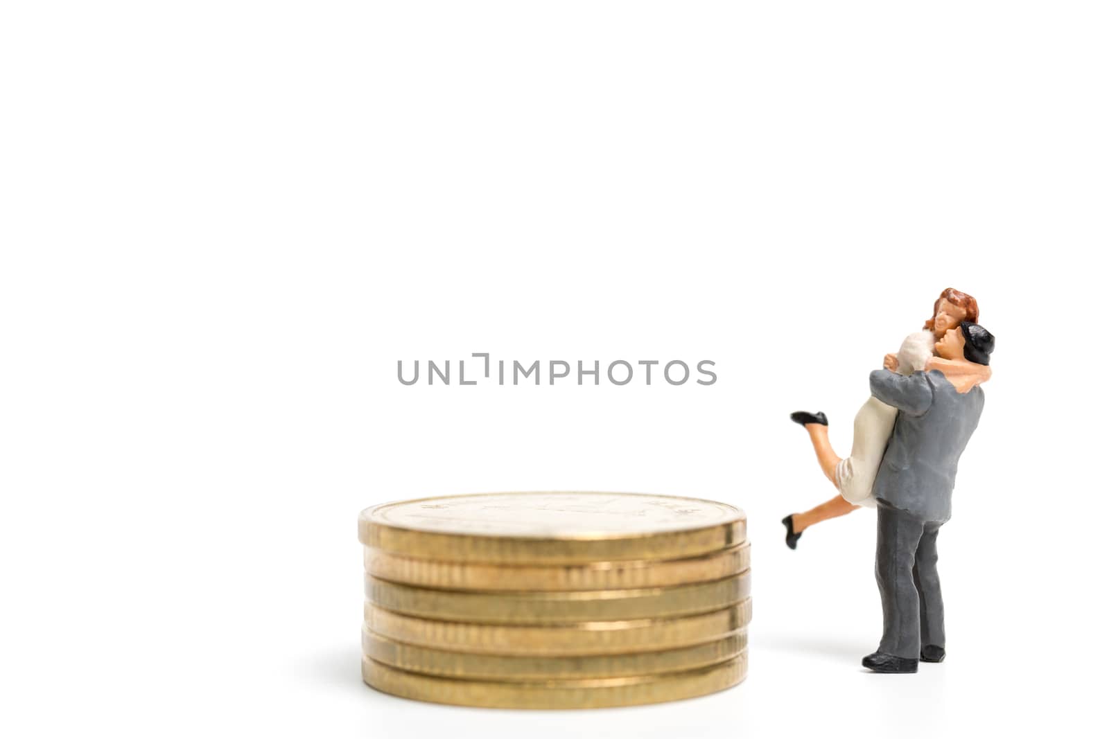 Miniature people: Couple hugging standing on stack of coin , Money and financial concepts.