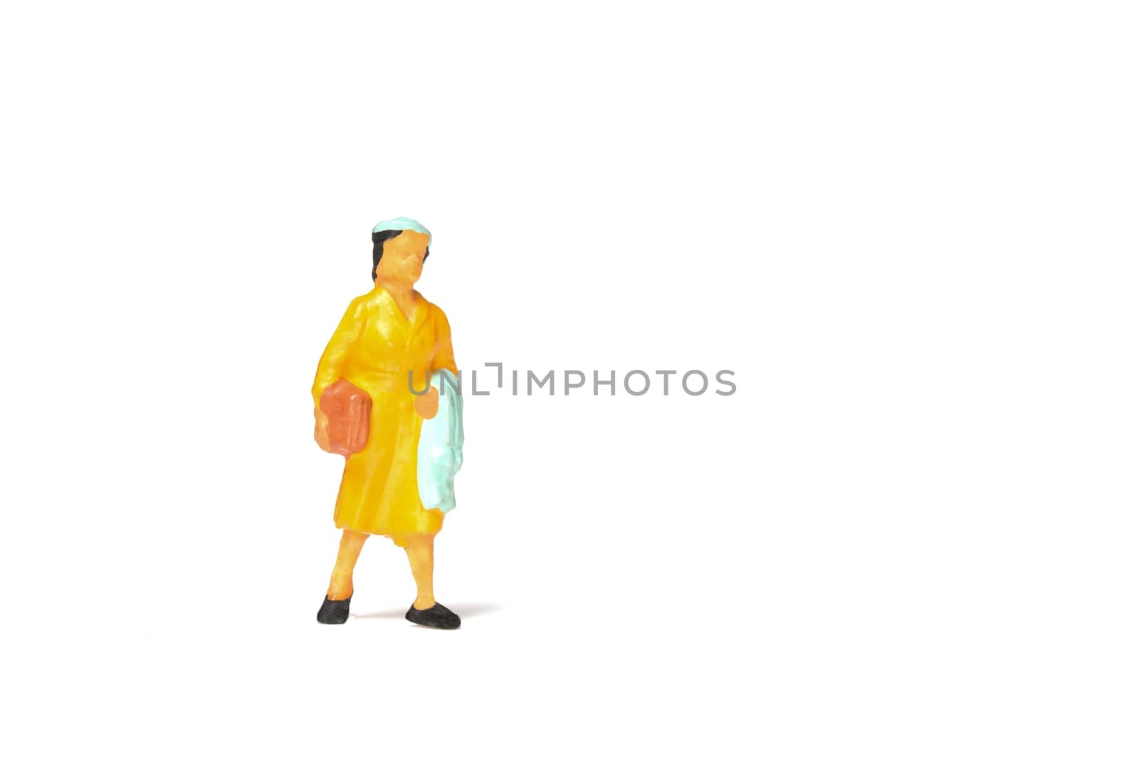 Miniature people ; Traveler holding a handbag standing on white background , Travel concept