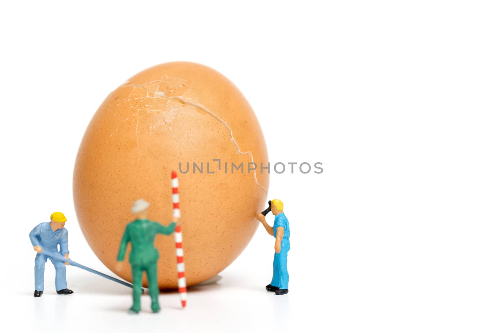 Miniature people work at Easter-eggs for Easter day on white background
