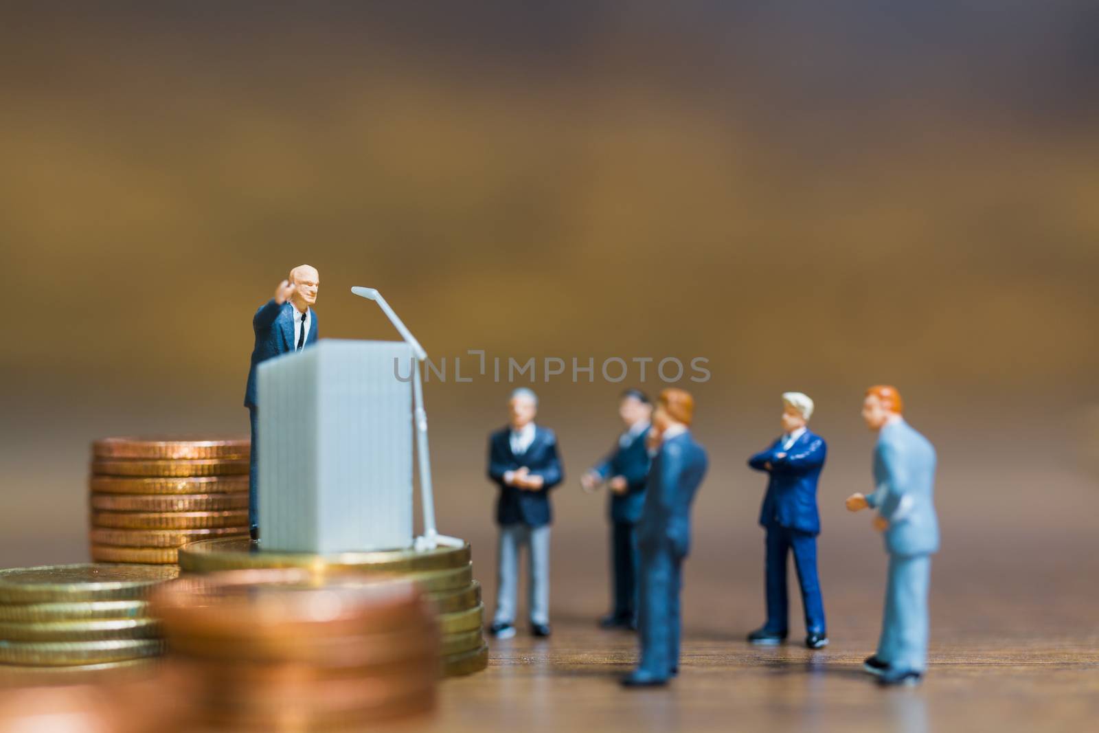 Miniature people : Businessman speaking on the podium , Business and finance investment concept