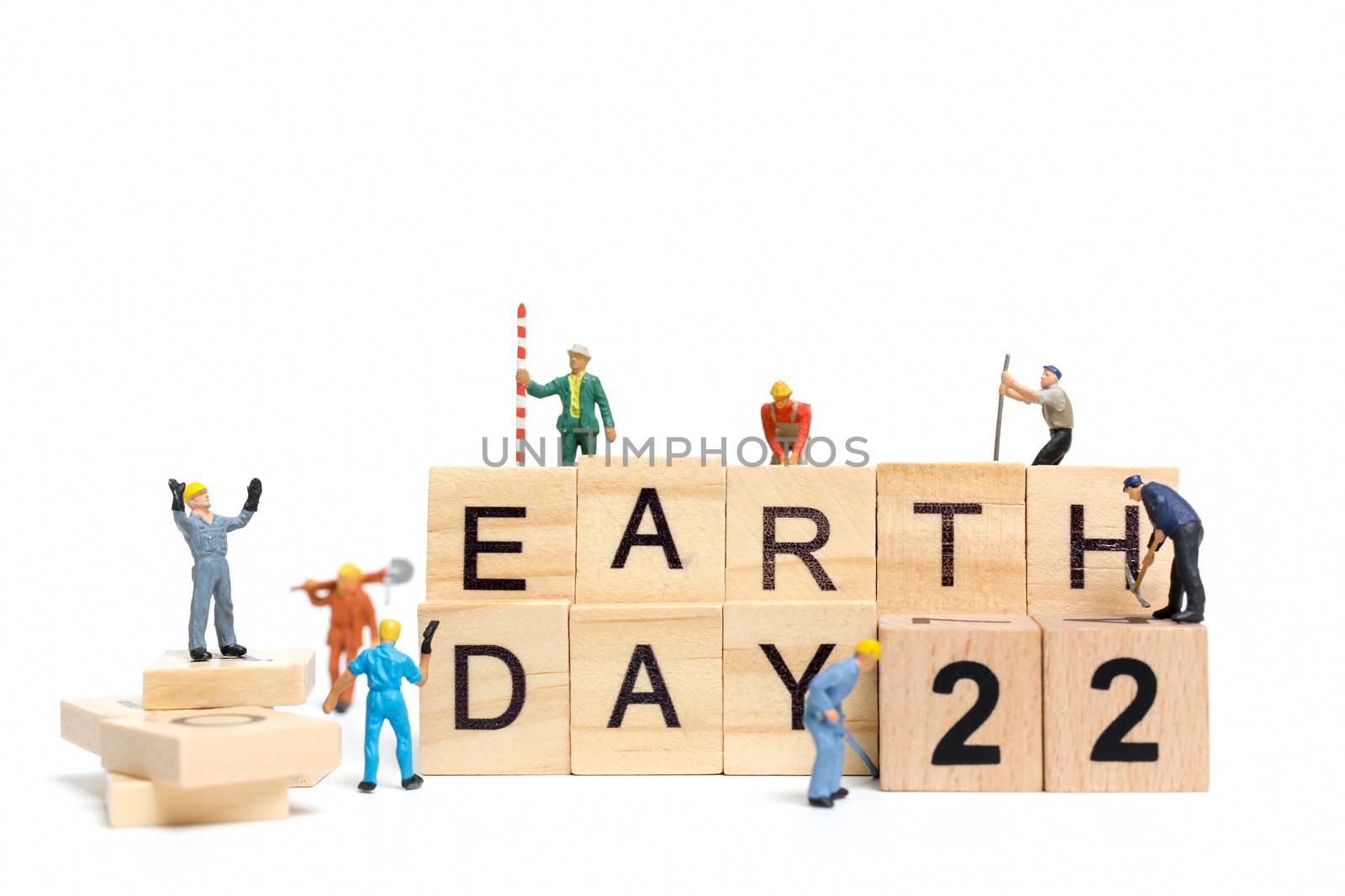 Miniature people : Worker team building word " Earth day " on wooden block with wooden background , Earth day concept