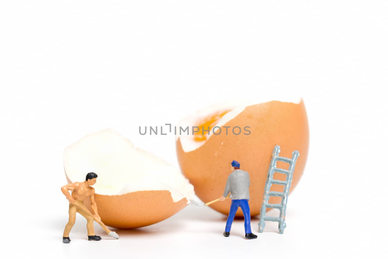 Miniature people work at Easter-eggs for Easter day on white background