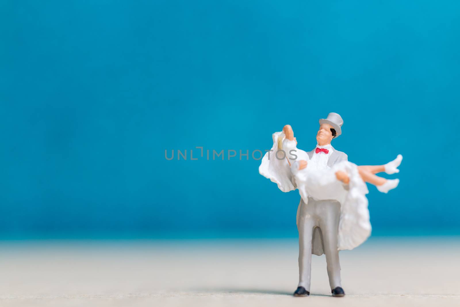 Miniature people : Bride and groom , Couple  on blue background.