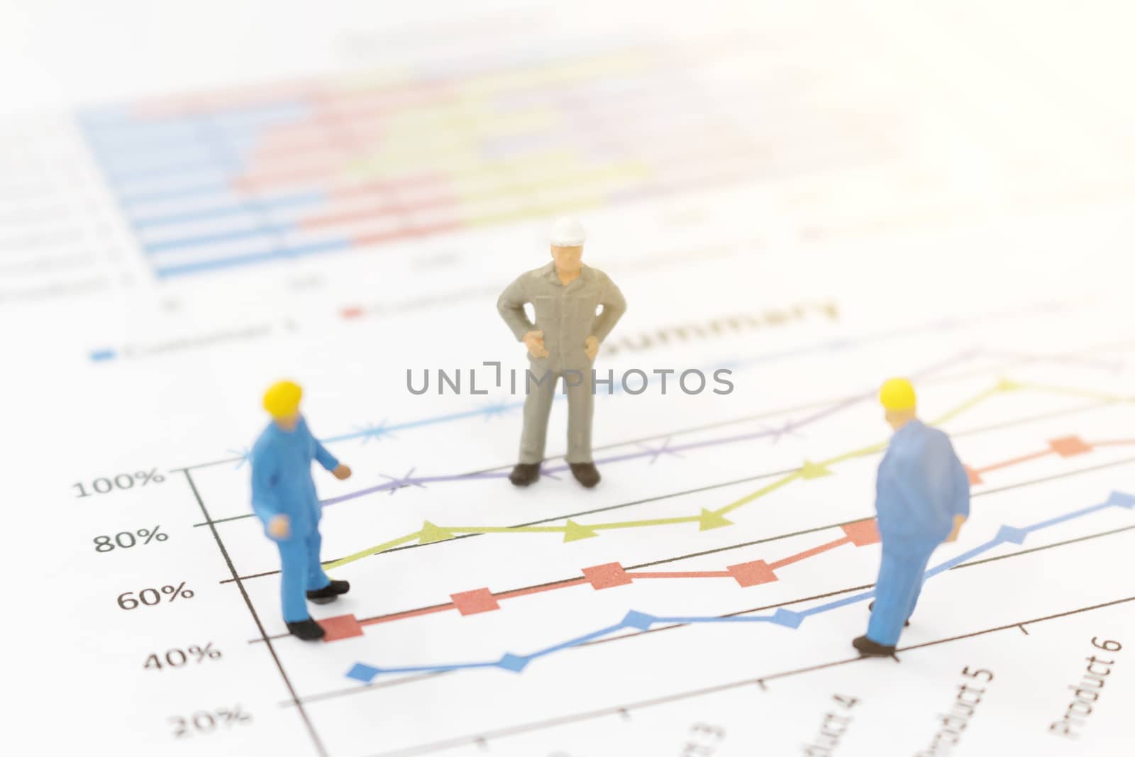 Miniature figures businessman standing on a graph chart  