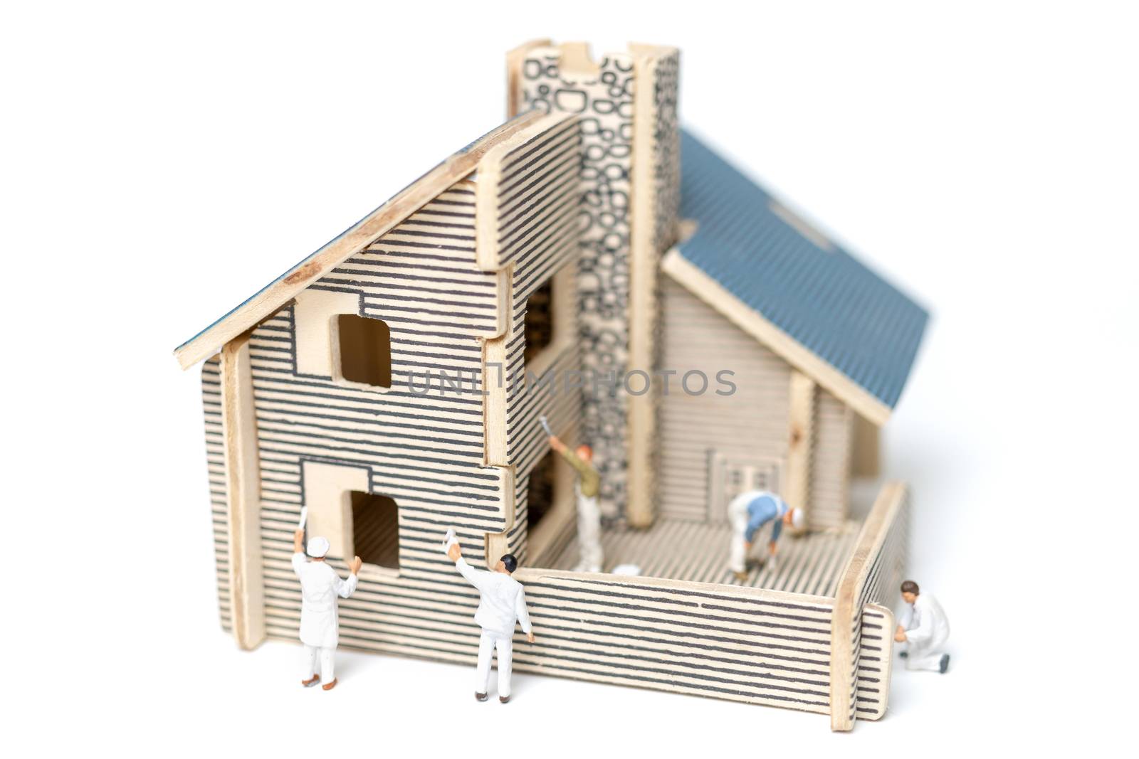 Miniature people : Paintbrush painting wooden house on white background