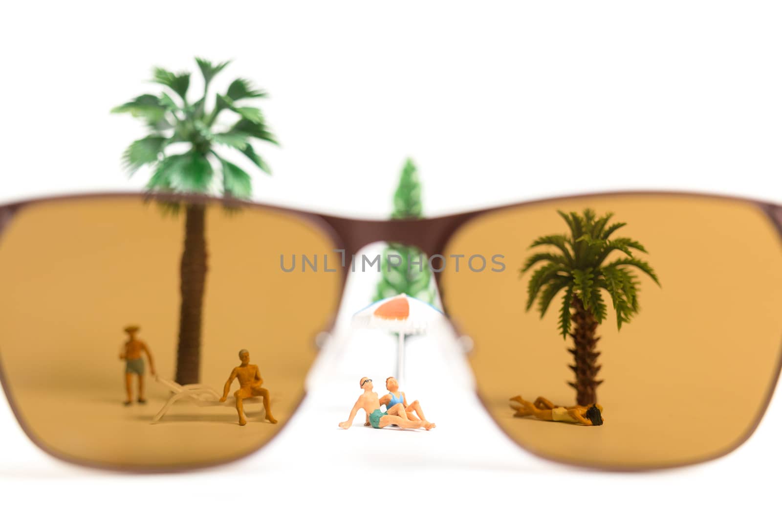 Miniature people wearing swimsuit relaxing on white background