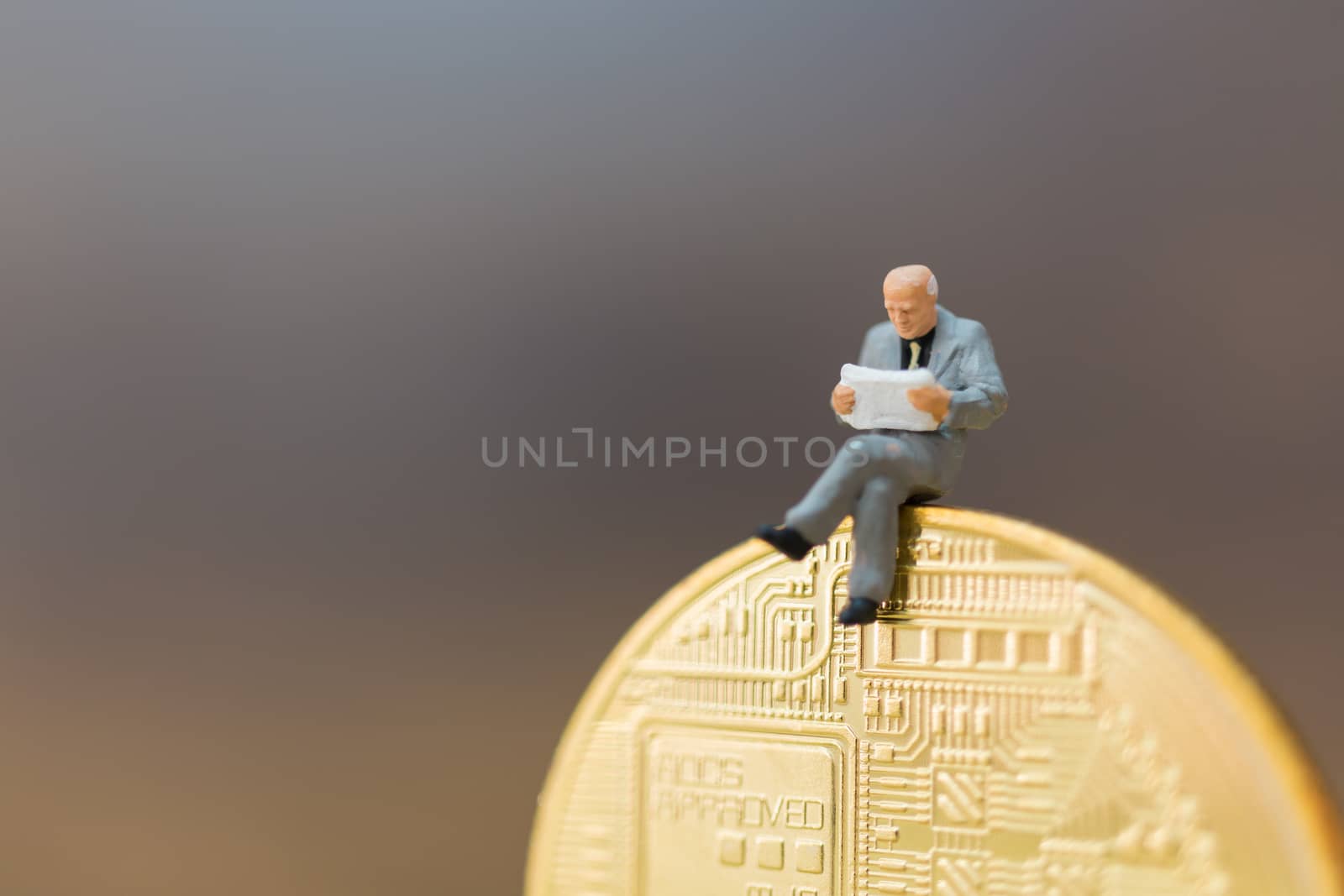 Miniature people: Businessman sitting on Bitcoin currency (Cryptocurrency)  , Business concept.