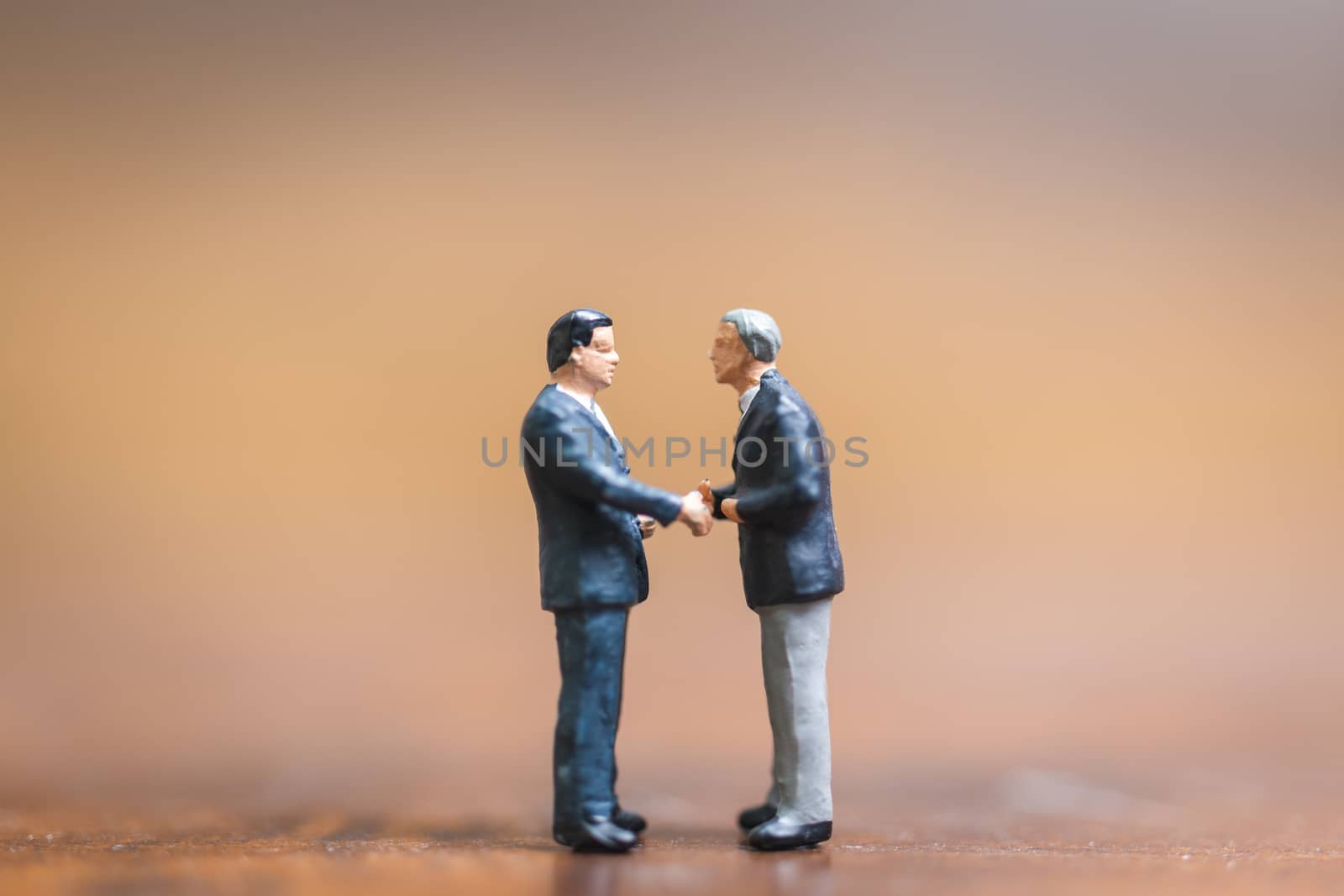 Miniature people Businessman standing on wooden background , Concept of Business leader and teamwork