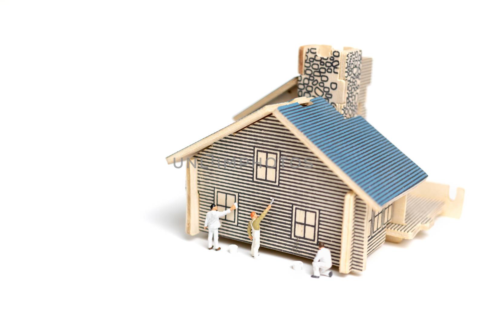 Miniature people : Paintbrush painting wooden house on white background