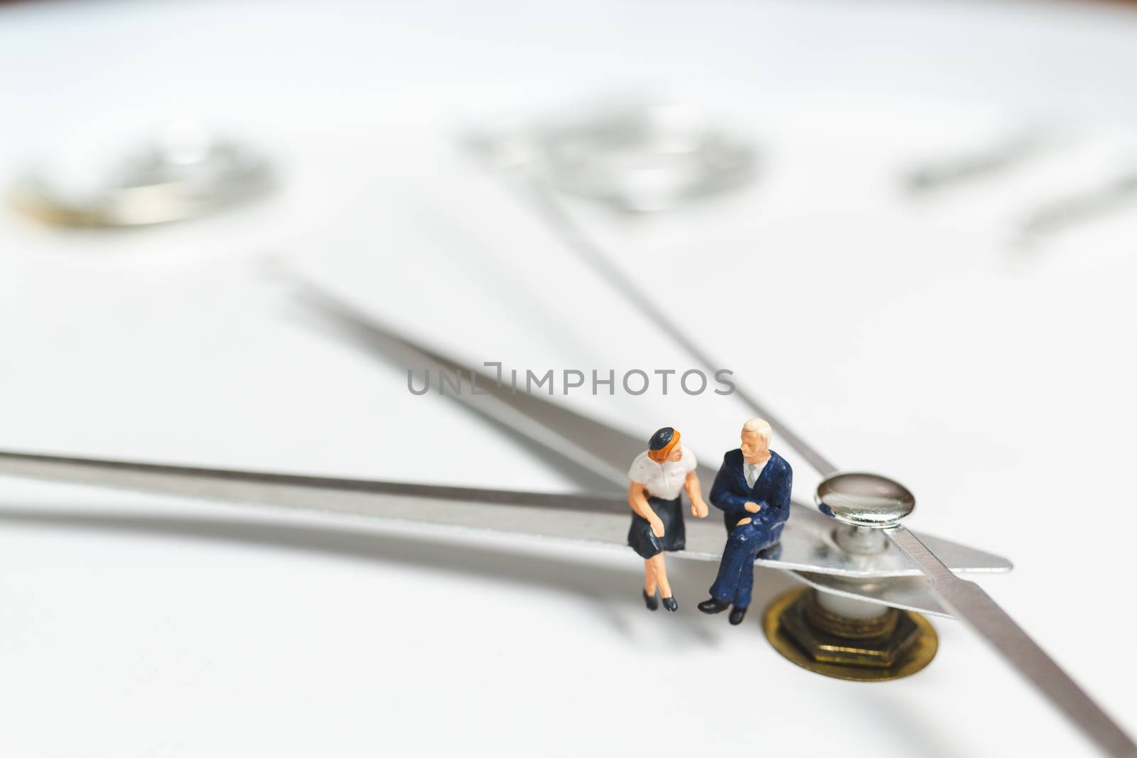 Miniature people Businessman sitting on clock , Concept of Time and Work