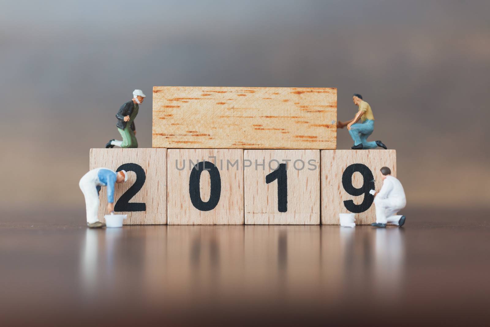 Miniature worker team painting  on wooden block , Happy new year 2019 concept